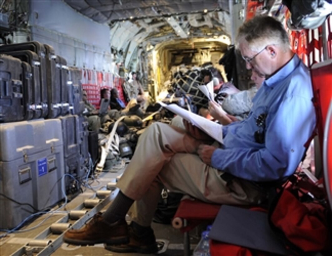 Deputy Secretary of Defense William J. Lynn III looks over some paperwork while flying on an Air Force C-130 Hercules aircraft after visiting Field Operation Base Salerno in Afghanistan on Sept.10, 2009.  