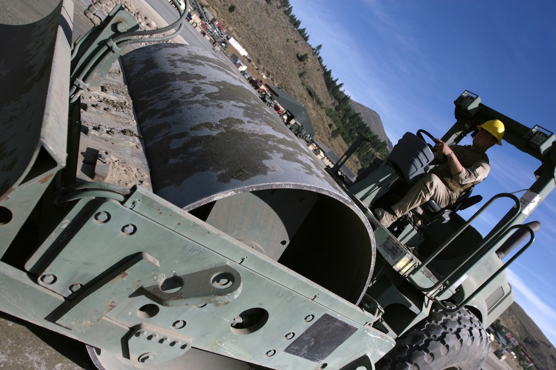 Lance Cpl. Bradley Sheets, a heavy equipment operator with engineer operations, Marine Wing Support Squadron 371 based out of Marine Corps Air Station Yuma, Ariz, drives a compactor to flatten a new section of the training center’s expeditionary airfield here Sept. 17. Sheets is one of a handful of Marines who were augmented to MWSS-373, based out of Marine Corps Air Station Miramar, Calif., to help complete the repairs and improvements to the EAF.