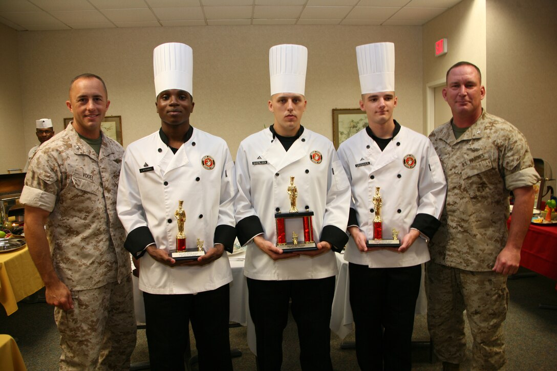 Food service specialists display their trophies with air station leaders at the chef of the Quarter competition, Sept. 17. From left to right are Headquarters and Headquarters Squadron commanding officer, Lt. Col Glenn C. Vogel; food service specialist Cpl. Louis E. Lafrance; Lance Cpl. Nickolas A. Sherlock and Lance Cpl. Brandon M. Croshier; and Col. Douglas A. Denn, Cherry Point’s commanding officer.