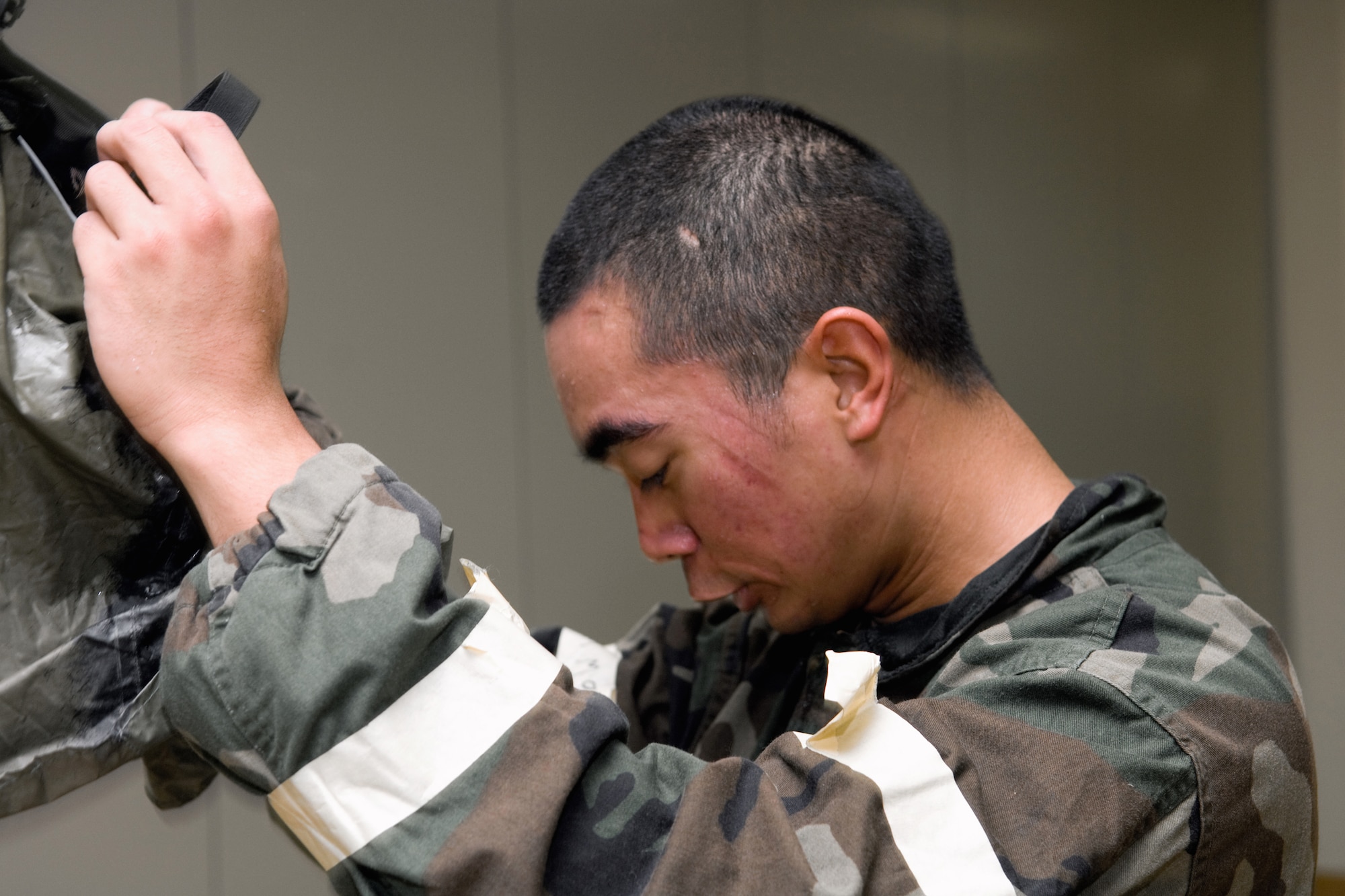 YOKOTA AIR BASE, Japan -- Airman 1st Class Francis Lapinig, 374th Security Forces Squadron, takes off his protective mask after competing in an Ability to Survive and Operate Rodeo PAR team competition Sept. 17 at the Taiyo Community Center. Post attack reconnaissance teams from throughout the base went head-to-head to see who was best. The 374th Logistics Readiness Squadron won the competition. The ATSO Rodeo covered areas of emphasis such as contamination control, unexploded ordnance identification and marking and asset protection in a chemical environment. (U.S. Air Force photo/Osakabe Yasuo)
