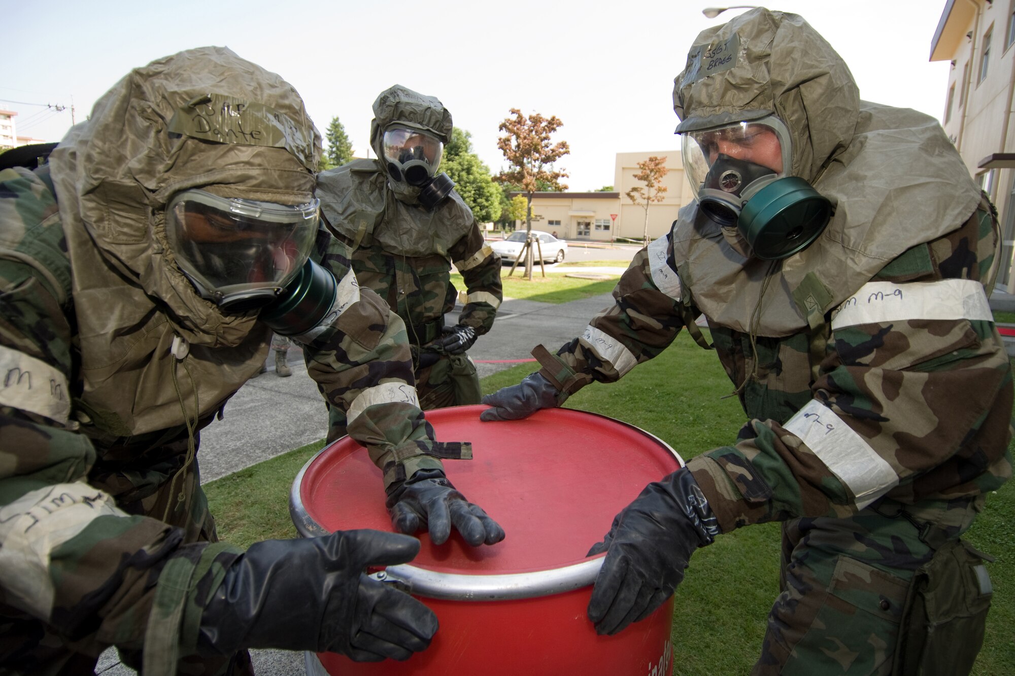 YOKOTA AIR BASE, Japan -- Airman 1st Class Dante Money (left) and Staff Sgt. Ethan Bragg, 374th Security Forces Squadron, open a simulated contaminated waste control and disposal container during an Ability to Survive and Operate Rodeo PAR team competition Sept. 17 at the Taiyo Community Center. Post attack reconnaissance teams from throughout the base went head-to-head to see who was best. The 374th Logistics Readiness Squadron won the competition. The ATSO Rodeo covered areas of emphasis such as contamination control, unexploded ordnance identification and marking and asset protection in a chemical environment. (U.S. Air Force photo/Osakabe Yasuo)
