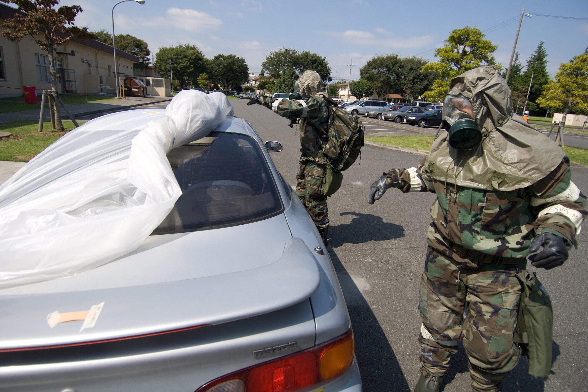 YOKOTA AIR BASE, Japan -- The 374th Security Forces Squadron Post Attack Reconnaissance team removes the covering of a simulated contaminated vehicle  during an Ability to Survive and Operate Rodeo PAR team competition Sept. 17 at the Taiyo Community Center. PAR teams from throughout the base went head-to-head to see who was best. The 374th Logistics Readiness Squadron won the competition. The ATSO Rodeo covered areas of emphasis such as contamination control, unexploded ordnance identification and marking and asset protection in a chemical environment. (U.S. Air Force photo/Osakabe Yasuo)
