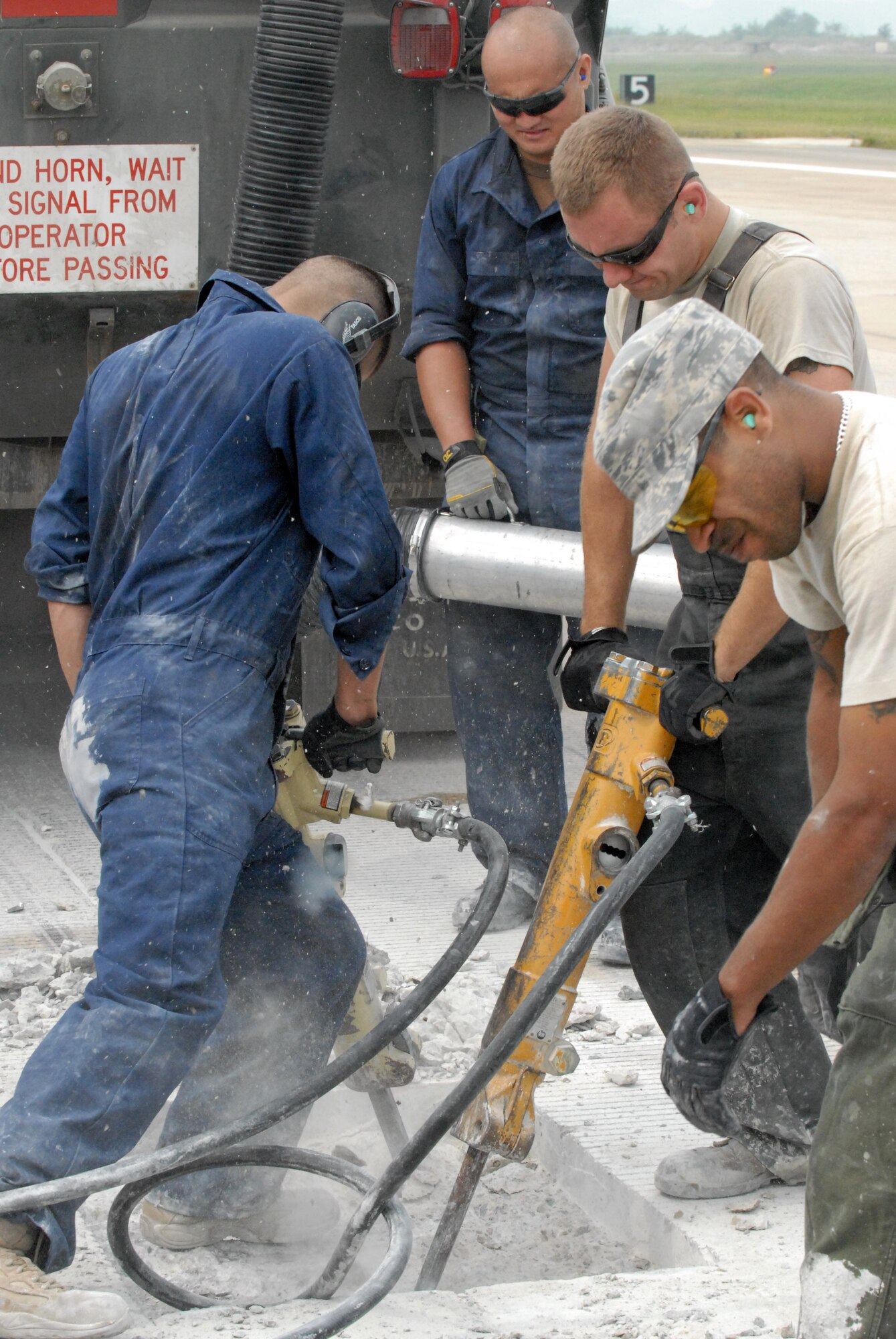 Senior Airman Jesus Medina (left) and Staff Sgt. Peter Ahleong work with a jackhammer on a piece of the Osan Air Base flightline during a major repair project Sept. 17. The flightline is closed to all operations until Oct. 3 due to the repairs. (U.S. Air Force photo by 1st Lt. Chris Hoyler) 