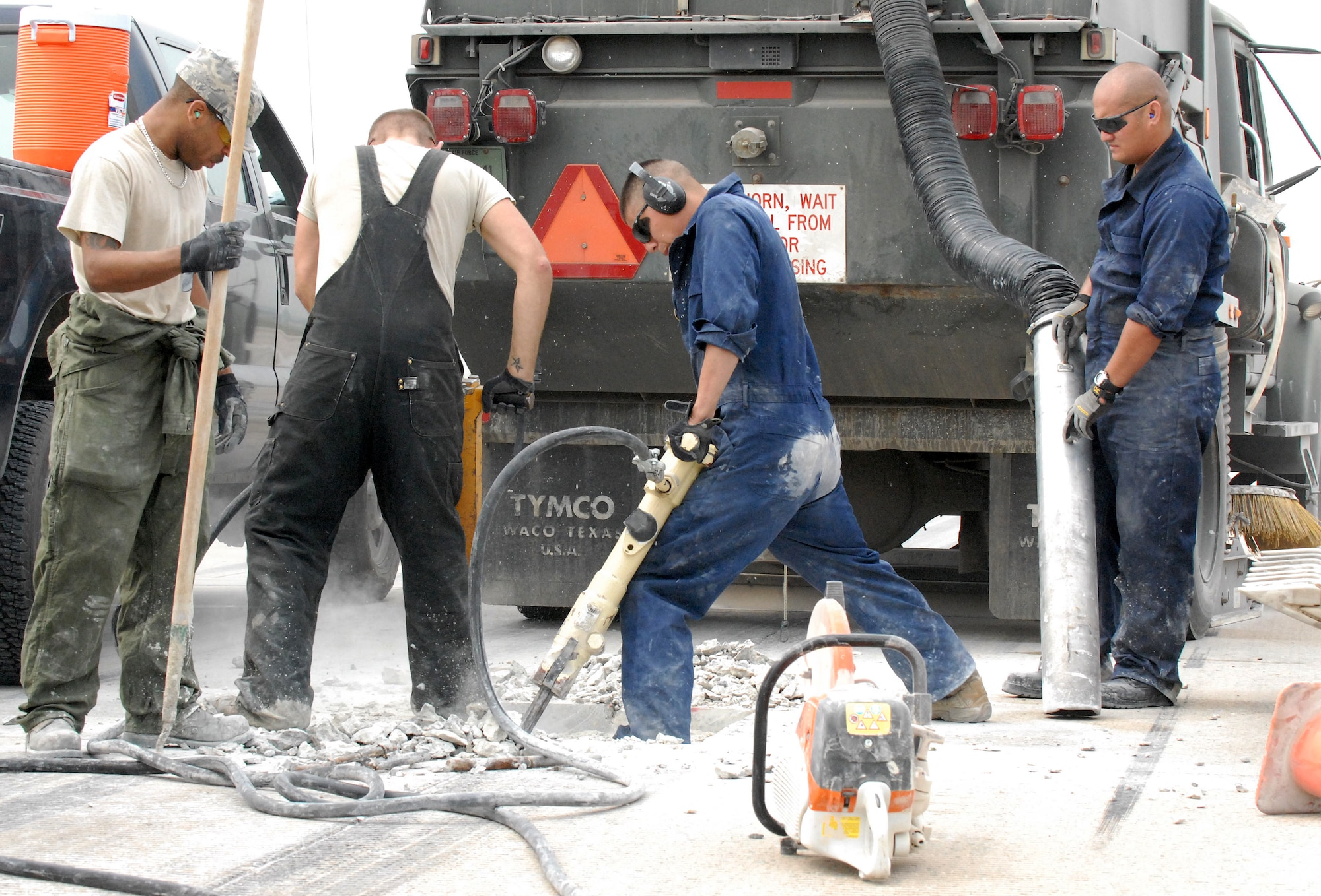 Tech. Sgt. Eric Rossin, Staff Sgt. Peter Ahleong, Senior Airman Jesus Medina and Senior Airman Brandon Trinkle, all 51st Civil Engineer Squadron, repair the eastern portion of Osan Air Base's flightline Sept. 17. The flightline is shut down for two weeks due to the repairs. (U.S. Air Force photo by 1st Lt. Chris Hoyler)