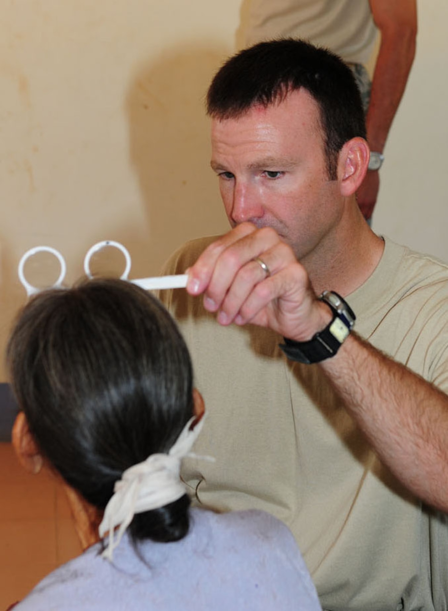 Capt. (Dr.) Chad Thompson, an optometrist from the 931st Air Refueling Squadron at McConnell Air Force Base, Kansas, examines a Vietnamese woman Sept. 18 in Quang Tri Province, Vietnam. Dr. Thompson and other U.S. military members are participating in Operation Pacific Angel 2009 to provide humanitarian assistance in cooperation with local authorities to Quang Tri Province residents Sept. 15-24. Pacific Angel is a Pacific Air Forces operation led by 13th Air Force at Hickam Air Force Base, Hawaii. The joint and combined humanitarian assistance operation is conducted in the Pacific area of responsibility to support U.S. Pacific Command’s capacity-building efforts. (U.S. Air Force photo/Tech. Sgt. Kerry Jackson) 