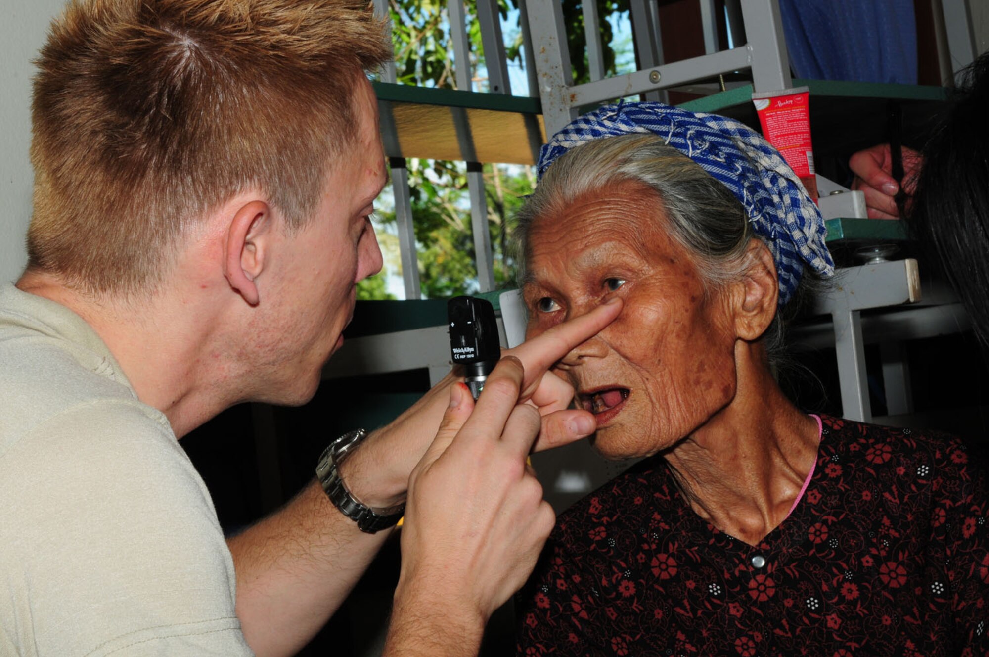 Maj. (Dr.) Steven Tittl, an optometrist assigned to the 439th Aerospace Medical Squadron at Westover Air Reserve Base, Mass., examines the eyes of a Vietnamese woman Sept. 18 in Quang Tri Province, Vietnam.  Dr. Tittl and other U.S. military members are participating in Operation Pacific Angel 2009 Sept. 15-24 to provide humanitarian assistance in cooperation with local authorities to Quang Tri Province residents. Pacific Angel is a Pacific Air Forces operation led by 13th Air Force at Hickam Air Force Base, Hawaii. The joint and combined humanitarian assistance operation is conducted in the Pacific area of responsibility to support U.S. Pacific Command’s capacity-building efforts. (U.S. Air Force photo/Tech. Sgt. Kerry Jackson) 