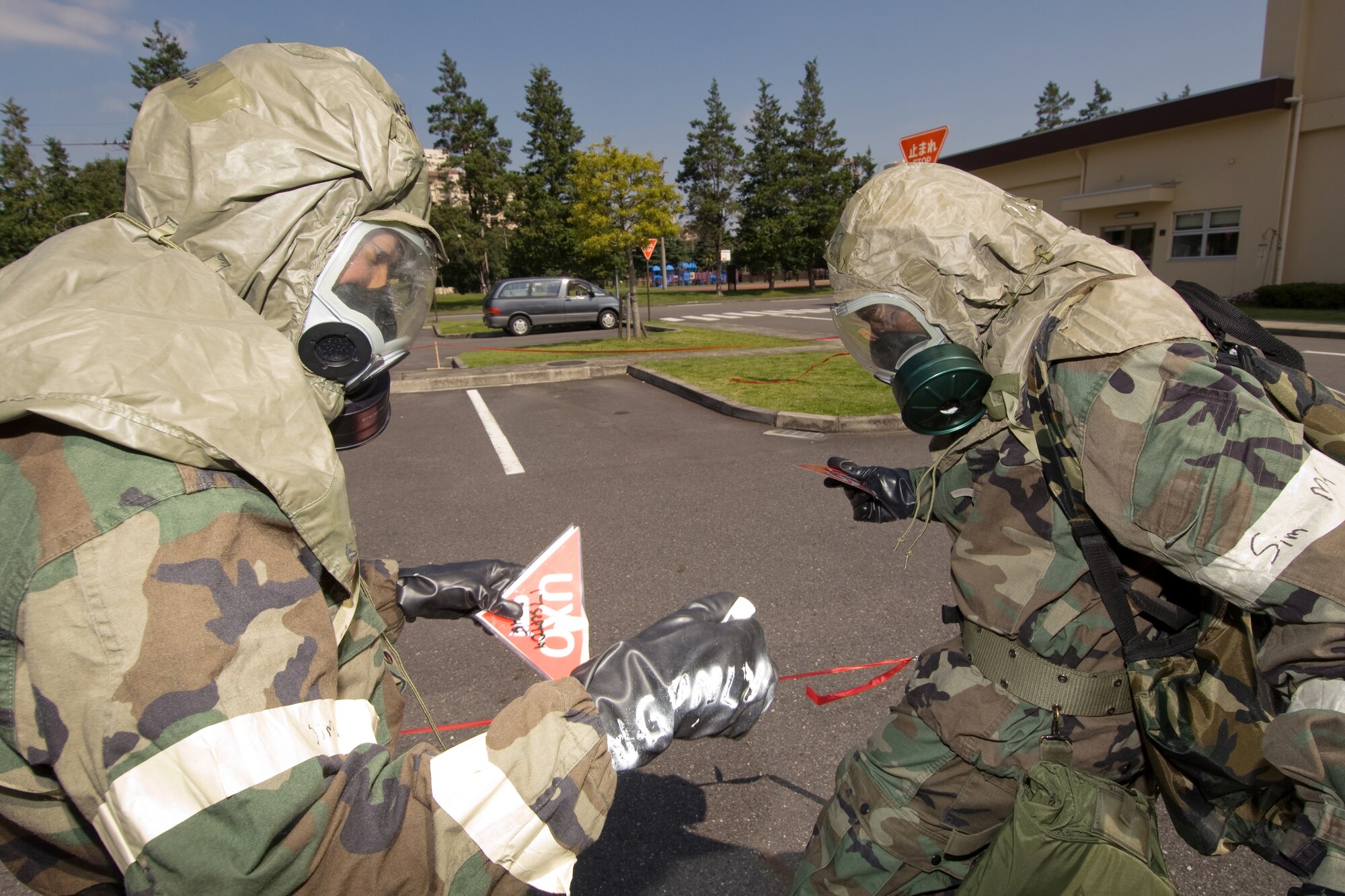 YOKOTA AIR BASE, Japan -- Airman 1st Class Francis Lapinig (left) and Airman 1st Class Dante Money, 374th Security Forces Squadron, set up an unexploded ordnance cordon during an Ability to Survive and Operate Rodeo PAR team competition Sept. 17 at the Taiyo Community Center. Post attack reconnaissance teams from throughout the base went head-to-head to see who was best. The 374th Logistics Readiness Squadron won the competition. The ATSO Rodeo covered areas of emphasis such as contamination control, unexploded ordnance identification and marking and asset protection in a chemical environment. (U.S. Air Force photo/Osakabe Yasuo)
