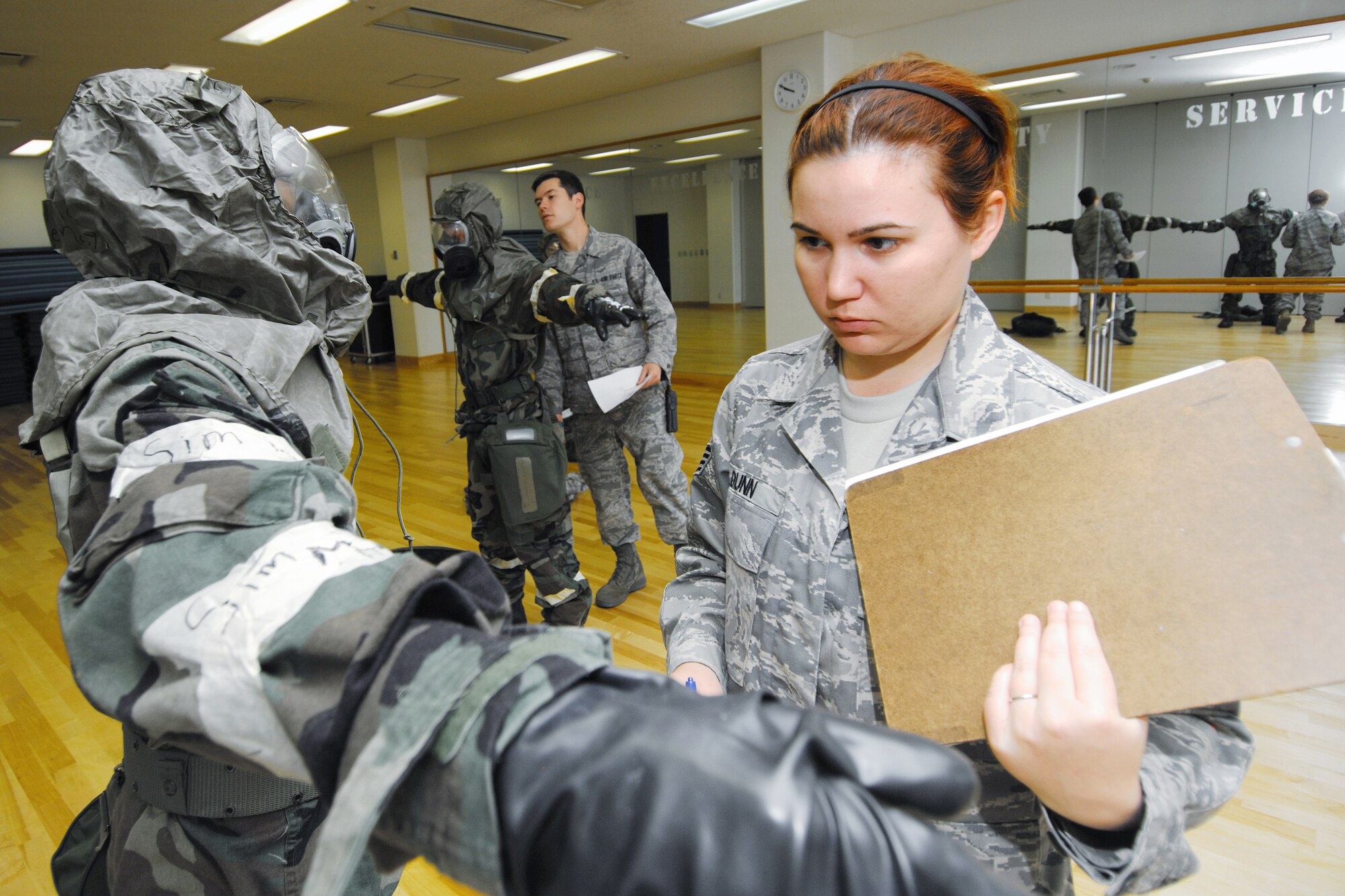 YOKOTA AIR BASE, Japan -- Staff Sgt. Melissa Dunn, 374th Civil Engineer Squadron Readiness Flight, inspects the chemical protective overgarment of a competitor during an Ability to Survive and Operate Rodeo PAR team competition Sept. 17 at the Taiyo Community Center. Post attack reconnaissance teams from throughout the base went head-to-head to see who was best. The 374th Logistics Readiness Squadron won the competition. The ATSO Rodeo covered areas of emphasis such as contamination control, unexploded ordnance identification and marking and asset protection in a chemical environment. (U.S. Air Force photo/Osakabe Yasuo)

