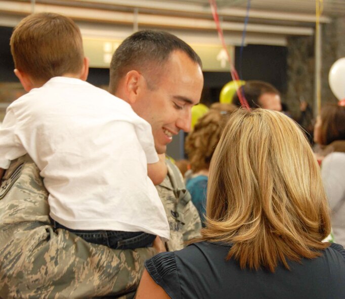 Staff Sgt. Reid McKinnon hugs his son and family members at the Anchorage International Airport Sunday, Sept. 13 after returning from his six month deployment to Iraq.   Staff Sgt. McKinnon is part of the 477th Fighter Group Civil Engineer Squadron and one of the 37 Airmen who deployed to Kirkuk Air Base, Iraq, for the past four to six months. During their deployment, the Airmen worked with other Airmen, soldiers, and Iraqi fliers to repair roads and runway and reconstruct shrines for public use.  The Airmen also helped train and teach local nationals on several construction techniques.  The deployment was the first full unit deployment for the squadron and first for the 477th FG.  (Air Force Photo / Tech. Sgt. Craig Dunbar)