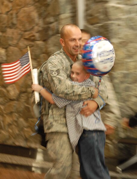Staff Sgt. Mark Silvia gives his son a bear hug at the Anchorage International Airport Sunday, Sept. 13 after walking off the plane returning from his six month deployment to Iraq.   Staff Sgt. Silvia is part of the 477th Fighter Group Civil Engineer Squadron and one of the 37 Airmen who deployed to Kirkuk Air Base, Iraq, for the past four to six months. During their deployment, the Airmen worked with other Airmen, soldiers, and Iraqi fliers to repair roads and runway and reconstruct shrines for public use.  The Airmen also helped train and teach local nationals on several construction techniques.  The deployment was the first full unit deployment for the squadron and first for the 477th FG. (Air Force Photo / Tech. Sgt. Craig Dunbar)