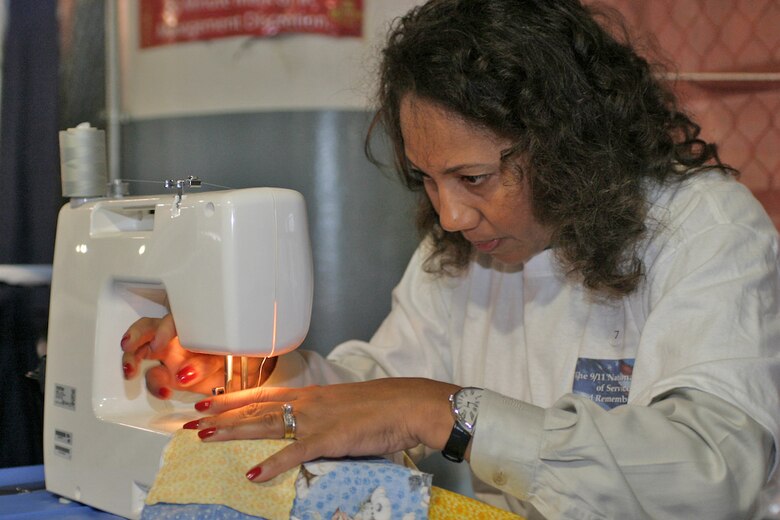 Almost 200 volunteers spent Sept. 11 participating in a Quilt-a-thon for Operation Kid Comfort, a National Day of Service activity in Washington, D. C.  Alisa Dotson, a member of the IBM quilt team, joined others as they worked toward completing 40 quilts. The quilts feature family photos of deployed service members and are given to children 6 years old and younger. (U.S. Air Force photo/Master Sgt. Paul Dean)