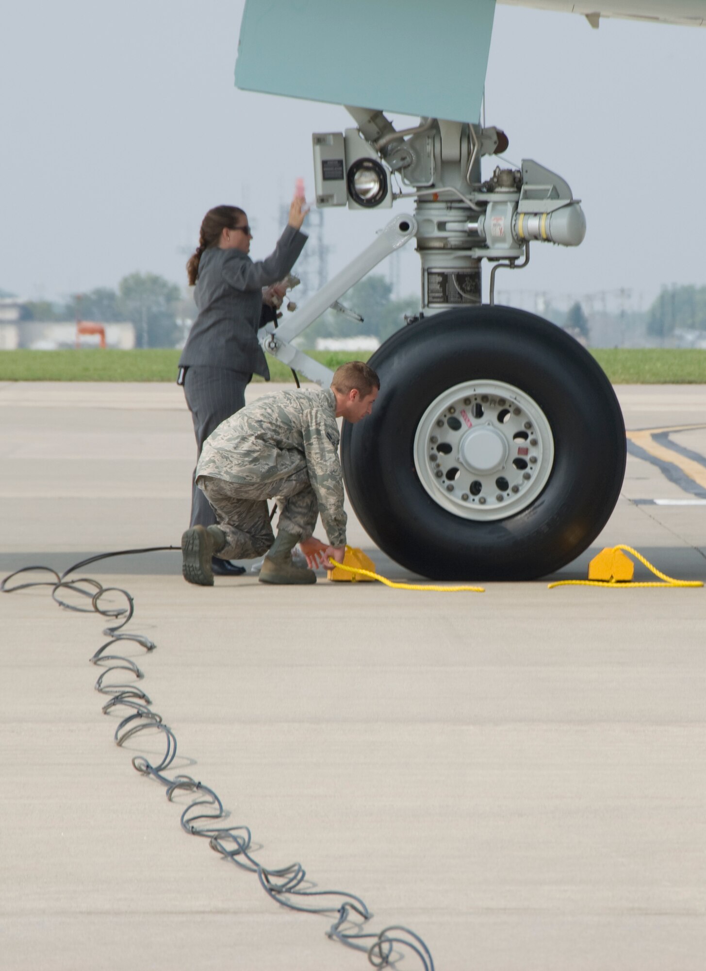 Airman 1st Class Stephen Lieser of the 133rd Aircraft Maintenance Squadron puts the chocks under the nose wheels of Air Force One on Sept. 12, 2009 while a White House staff member plugs in communication lines provided by the 133rd Communications Flight. Air Force One brought President Barak Obama to the Air Guard base at the Minneapolis, St. Paul International Airport for a speech in Minneapolis,  and the 133rd Airlift Wing of the Minnesota Air National Guard provided support to the commander in chief. USAF Official Photo by Tech. Sgt. Dan Payette.