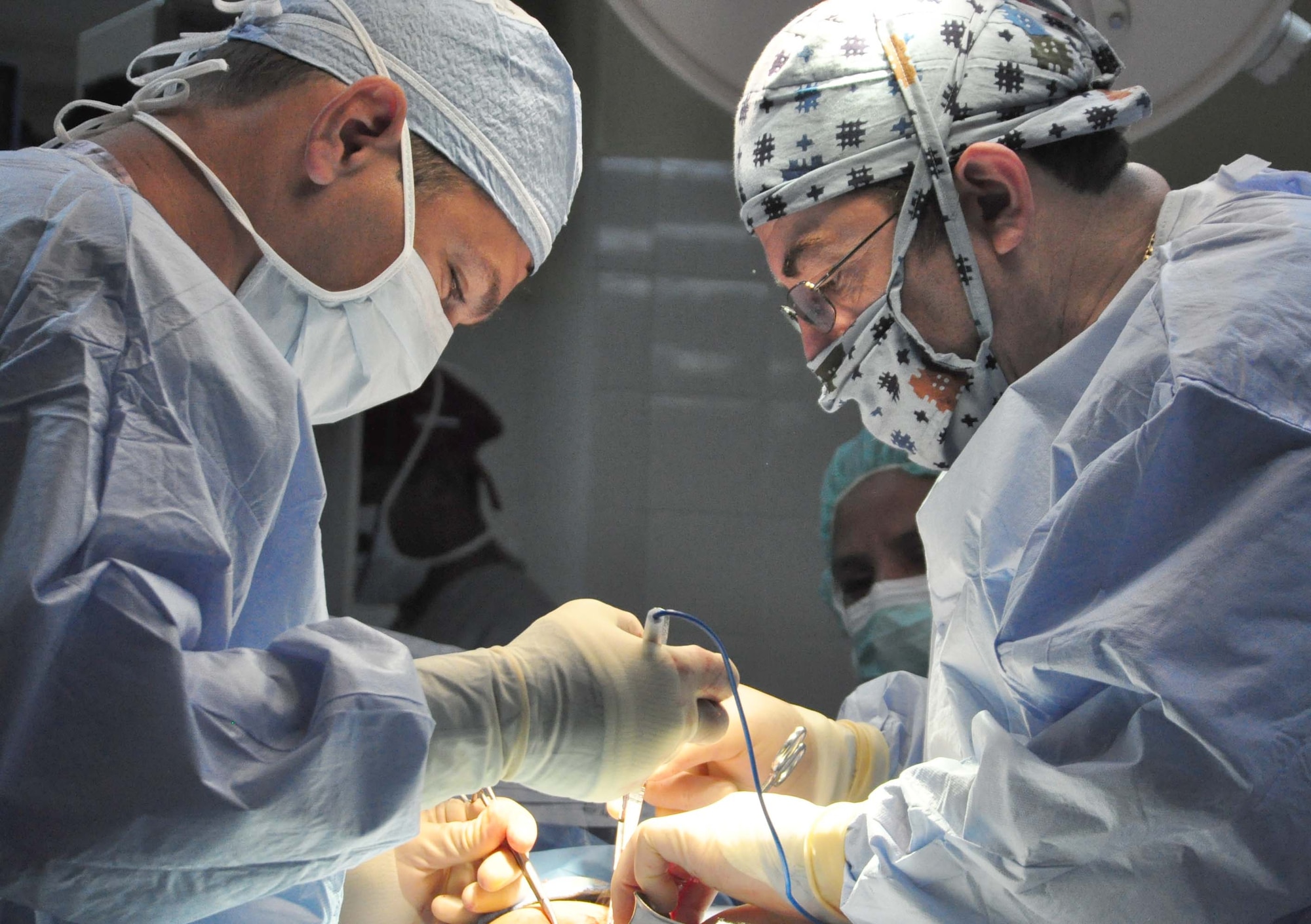 SOTO CANO AIR BASE, Honduras — Army Lt. Col. (Dr.) Christopher Sanborn, JTF-Bravo Medical Element surgeon, assists Dr. Jose Angel Mejia with a gallbladder surgery in a local hospital Sept. 16 in Comayagua, Honduras. Dr. Sanborn is part of a four-person team that goes to La Paz and Comayagua hospitals Tuesdays, Wednesdays and Thursdays to perform operations and lessen the burden on local doctors during these medical readiness training exercise, or MEDRETEs. The MEDRETE is used for training purposes for both local doctors and the military team (U.S. Air Force photo/Staff Sgt. Chad Thompson).