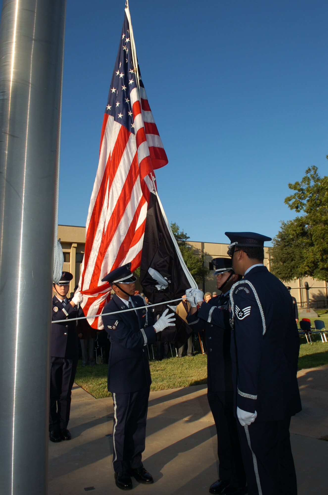 Members of the Air Force Intelligence, Surveillance and Reconnaissance Agency Color Guard unfurl the POW/MIA flag during ceremonies Sept. 17 at Lackland Air Force Base, Texas. The Agency's annual remembrance of those held prisoner of war and missing in action recognized five ex-POWs in attendance plus paid tribute to fallen comrades from the service branches. (Photo by William Belcher)    
