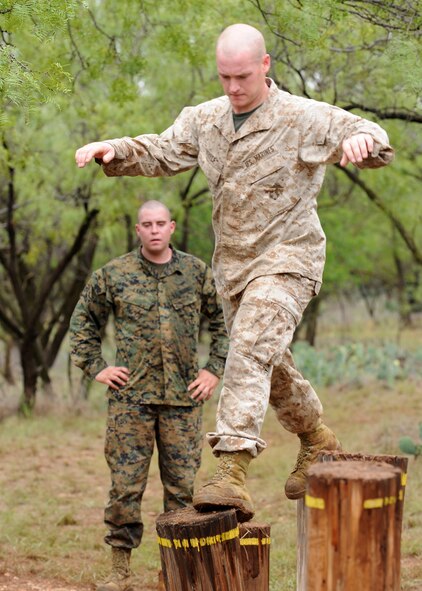 ABILENE, Texas -- Marine Cpl. James White (front) Detachment 1 motor transport maintenance company, hops across a balance obstacle while Lance Cpl. Zachary Lance ensures his teammate crosses safely Sept. 12 at the Abilene Police Academy obstacle course. Every year the Dyess Marines visit the rifle range or the Abilene Police Academy obstacle course to maintain their combat readiness skills and teamwork. The “field exercises” prepare the Marines for what they may encounter when performing missions in Afganistan and Iraq during their 6-18 month deployments.   (U.S Air Force photo by Senior Airman Jennifer Romig)