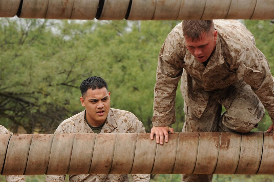 ABILENE, Texas -- Marine Cpl. Daniel Rubio (left), Detachment 1 motor transport maintenance company, and Lance Cpl. Michael Helstowski, prepare to jump over an obstacle Sept. 12 at the Abilene Police Academy obstacle course. Every year the Dyess Marines visit the rifle range or the Abilene Police Academy obstacle course to maintain their combat readiness skills and teamwork. The “field exercises” prepare the Marines for what they may encounter when performing missions in Afganistan and Iraq during their 6-18 month deployments.  (U.S Air Force photo by Senior Airman Jennifer Romig)