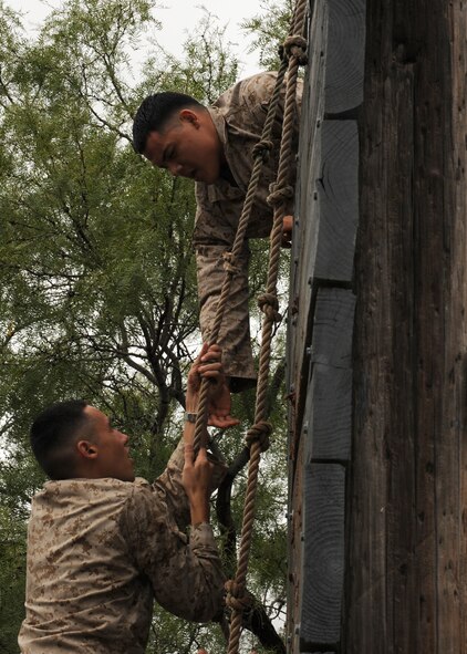 ABILENE, Texas -- Marine Cpl. Daniel Rubio, Detachment 1 motor transport maintenance company, helps Lance Cpl. Richard Mcmurry conquer an obstacle Sept. 12 at the Abilene Police Academy obstacle course. Every year the Dyess Marines visit the rifle range or the Abilene Police Academy obstacle course to maintain their combat readiness skills and teamwork. The “field exercises” prepare the Marines for what they may encounter when performing missions in Afganistan and Iraq during their 6-18 month deployments. (U.S. Air Force photo by Senior Airman Jennifer Romig)