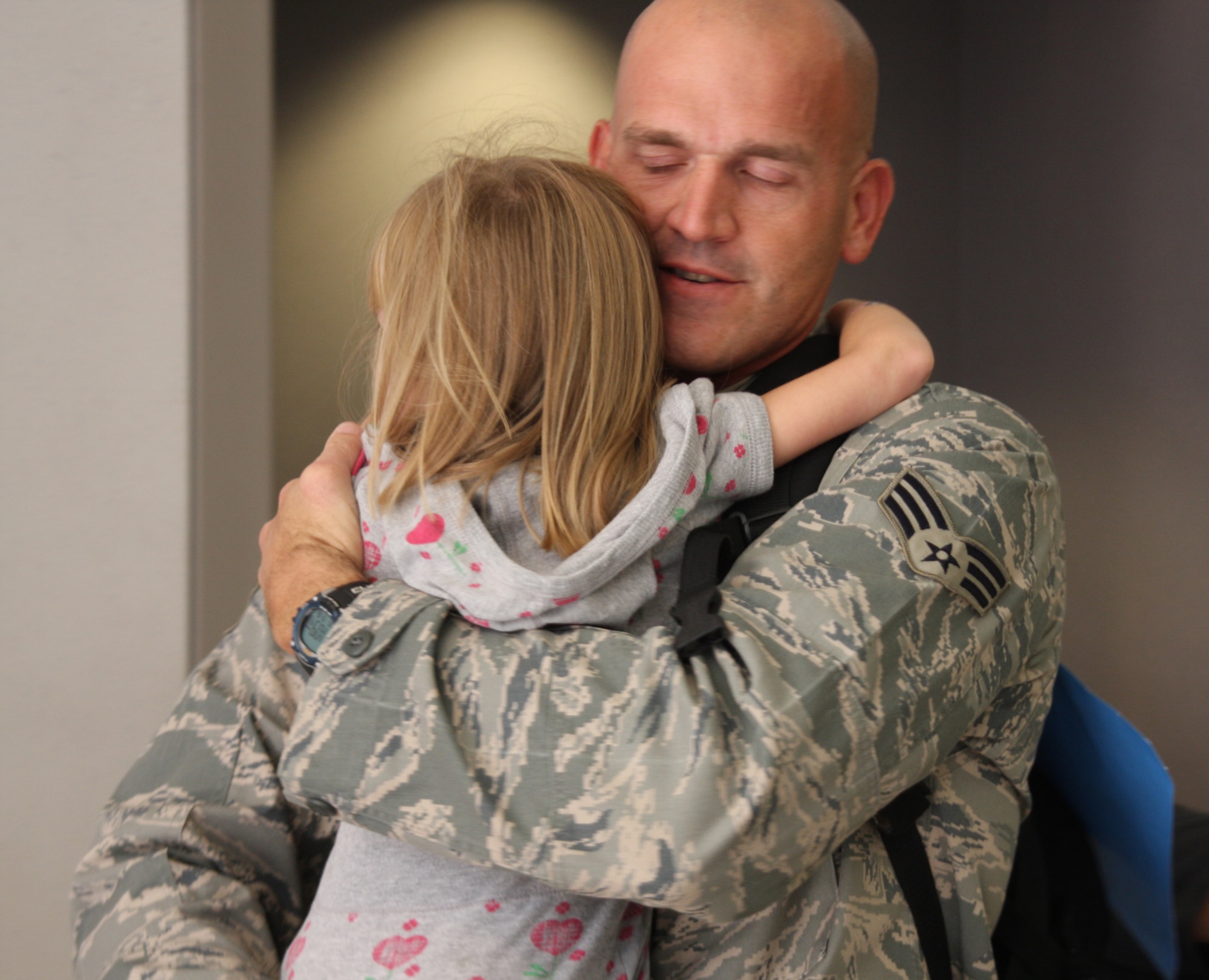 WRIGHT-PATTERSON AFB, Ohio - Senior Airman Steven Sherman, 87th Aerial Port Squadron, hugs his daughter Amelia, upon his return from a six-month deployment to Balad Air Base, Iraq.  More than 50 squadron members deployed to Southwest Asia this spring and will be returning throughout the month of September. (Air Force photo/Maj, Cynthia Harris)