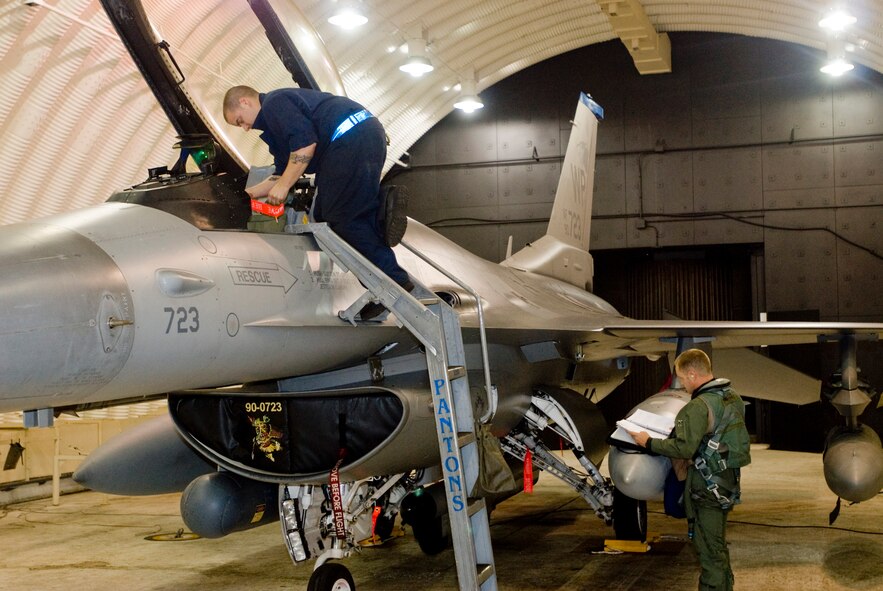 KUNSAN AIR BASE, Republic of Korea -- Staff Sgt. Jonathan Lima, 8th Aircraft Maintenance Squadron, 35th Aircraft Maintenance Unit, and Capt. Jason Monaco, 35th Fighter Squadron, prepare the F-16 for flight Sept. 18. The 35th FS heads to Eielson Air Force Base for Distant Frontier and Red Flag Alaska for month-long training. Distant Frontier gives the Wolf Pack team the chance to drop live and inert heavyweight munitions. Red Flag Alaska gives the pilots and maintainers an air combat training environment where multi-services, multi-platforms and their aircrews are run through every thinkable combat threat. (U.S. Air Force photo/Senior Airman Jonathan Steffen)