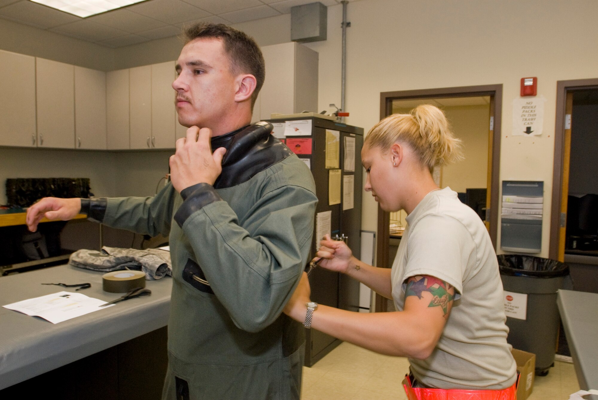 KUNSAN AIR BASE, Republic of Korea -- Staff Sgt. Kimberly Gage, 8th Operations Support Squadron, zips up an anti-exposure suit on 1st Lt. Brian Lewis, 35th Fighter Squadron, Sept. 18. The 35 FS will be heading to Eielson Air Force Base for Red Flag- Alaska for two weeks. The Red Flag- Alaska exercise is a no-nonsense, air combat training environment where multi-services, multi-platforms and their aircrews are run through every thinkable combat threat. (U.S. Air Force photo / Senior Airman Jonathan Steffen)