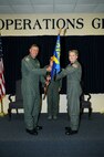 Colonel Douglas Schwartz, 927th Operations Group commander, passes the 927th Operations Support Flight flag to Lieutenant Colonel Erich Novak during an Assumption of Command ceremony Saturday (U.S. Air Force Photo/Capt. Shane Huff)