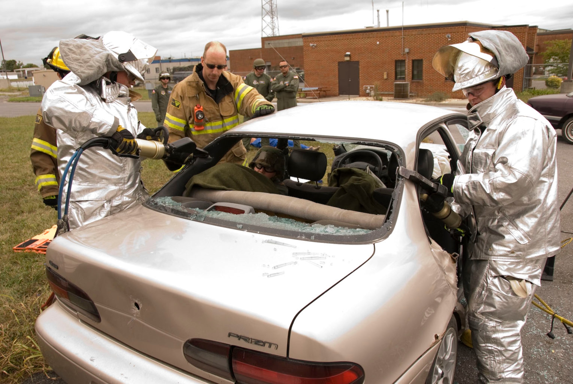 Staff Sgt. Joe Harper, center, and Tech. Sgt. Tara Bryant, inside car, both members of the 167th Aeromedical Evacuation Squadron, watch as 167th Fire Fighters Senior Airman Pierce Franklin and Senior Airman Mike Hurd use the Jaws of Life to remove the roof from a car during a training exercise at the 167th Airlift Wing, Martinsburg West Virginia, September 12, 2009. (U.S. Air Force Photo by Master Sgt Sean Brennan)