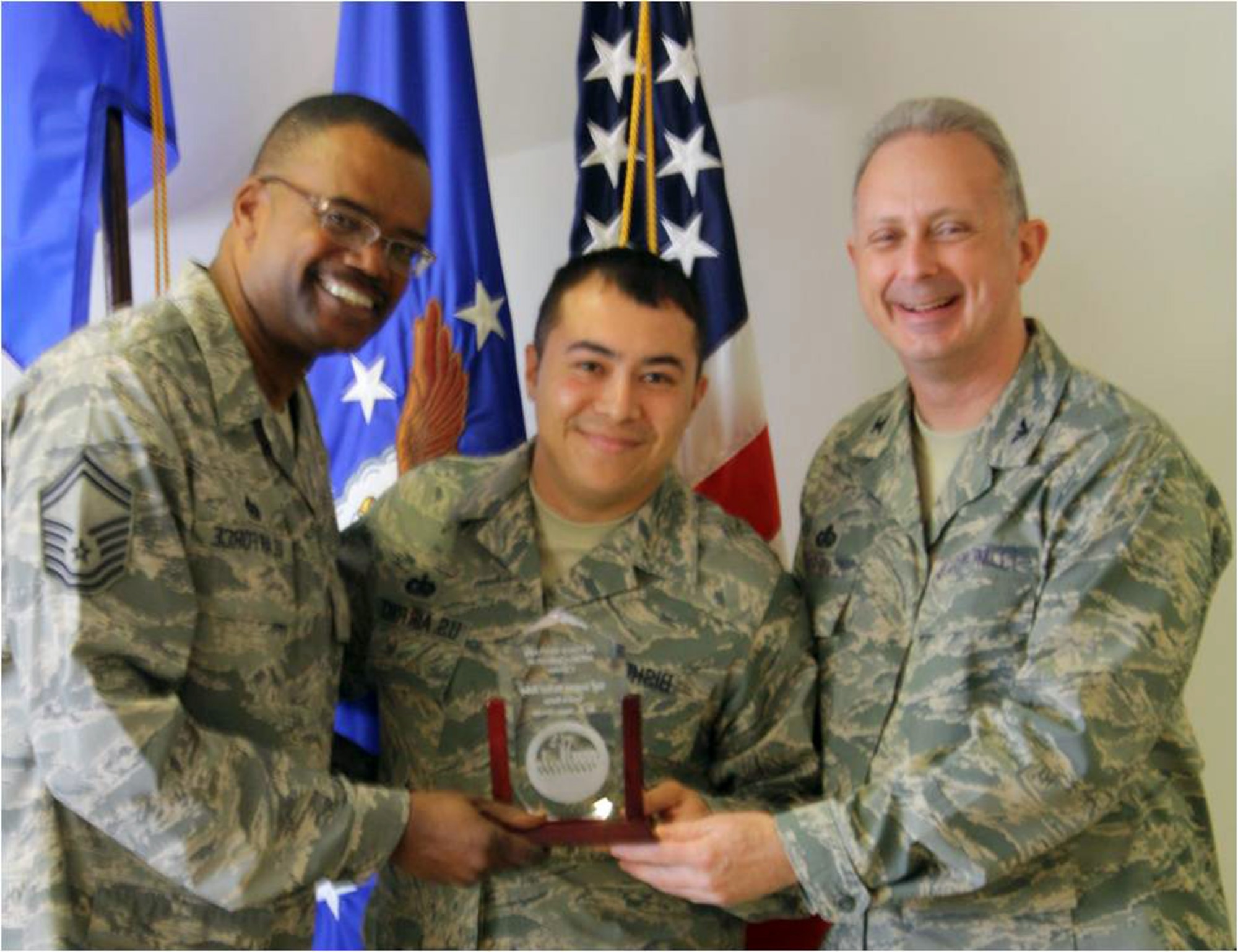 DOVER AIR FORCE BASE, Del.- Staff Sgt. Michael Bishop, center, a Services specialist with the 446th Services Flight, McChord Air Force Base, Wash., accepts his NCO of the Rotation Award from Senior Master Sgt. Stephen Harris, left, 446th SVF superintendent, and Col. Robert Edmondson, commander, Air Force Mortuary Affairs Operations Center here for his hard work and selfless service during his air expeditionary force rotation at AFMAOC. (U.S. Air Force photo/Capt. Sandra Bannan)