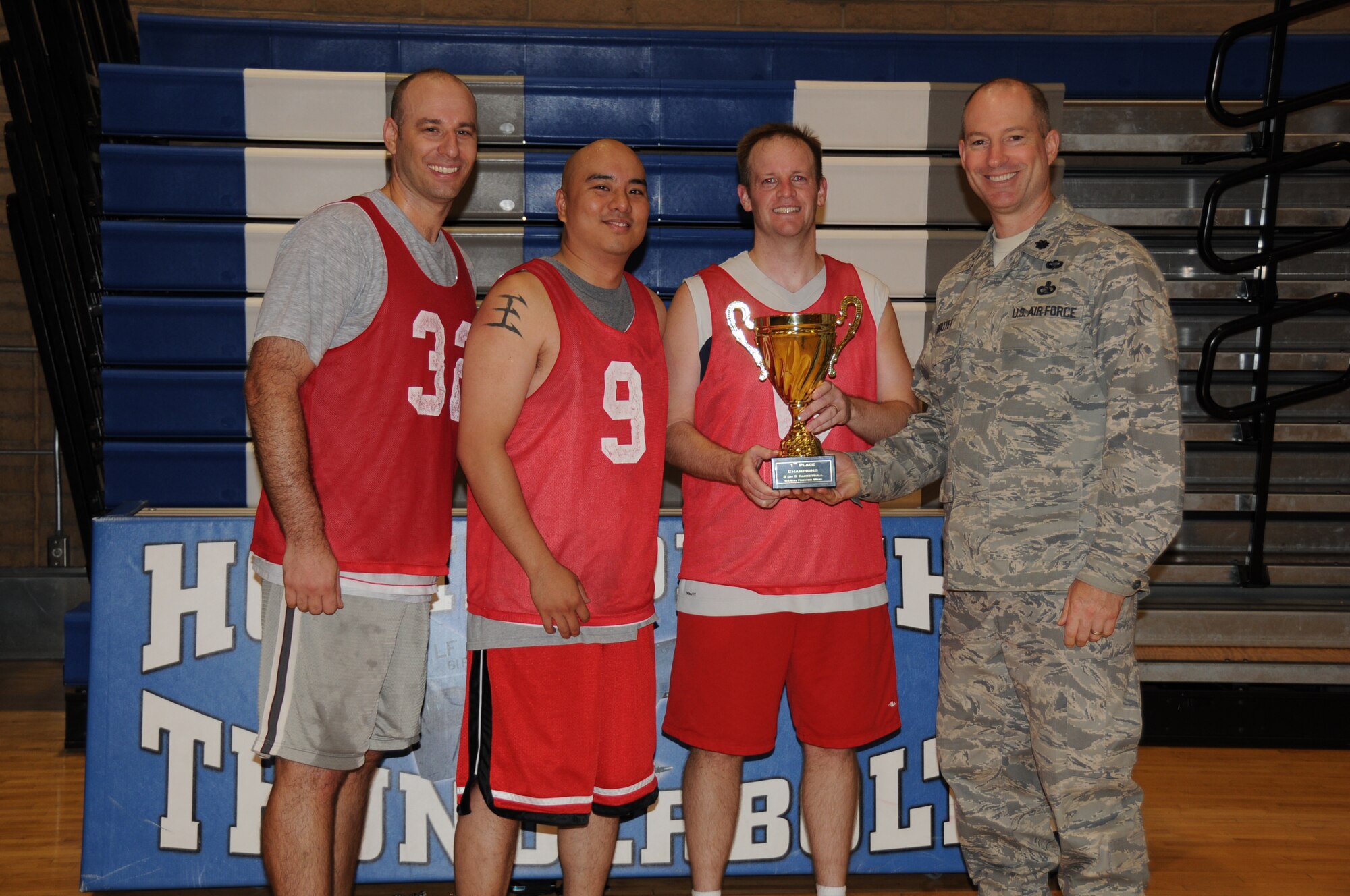 Lt. Col. Michael Boutet, 944th Mission Support Group deputy commander, presents the winning 944th Fighter Wing team with a trophy Sept. 16 after a 3-on-3 basketball tournament. The winners (from left to right) were Philip Wieser, Lonnie Sell and Arturo Tibayan. The 944th Services Flight put on the tournament for wing members during the mandatory home station annual tour to encourage fitness and camaraderie. (U.S. Air Force photo/Tech. Sgt. Susan Stout) 