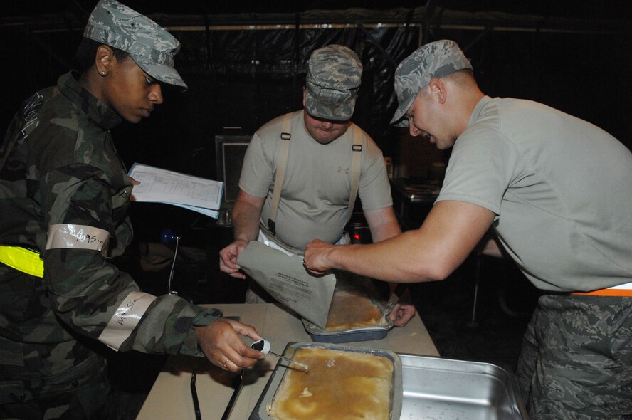 MINOT AIR FORCE BASE, N.D. -- Airman 1st Class Kiana Gorden and Tech. Sgt. Fred Nordstrom, 5th Force Support Squadron chefs, check the temperature of mash potatoes and gravy in preparation of a midnight meal during combat operations at Base X here Sept. 9. (U.S. Air Force Photo by Staff Sgt. Miguel Lara)