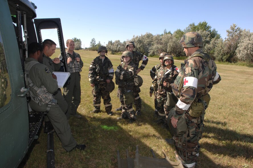 MINOT AIR FORCE BASE, N.D.-- Members of the 5th Medical Group prepare to load wounded personnel into a Huey helicopter during combat operations Sept. 9. as part of the Prairie Knight exercise Sept. 9 to 10.  Prairie Knight is a phase II exercise designed to demonstrate unit capability to conduct sustained combat and mission support operations under simulated combat conditions. While the skill and professionalism of deployed medical teams is second to none, some medial situations require patients to be evacuated to receive life-saving care. (U.S. Air Force Photo by Staff Sgt. Stacy Moless)