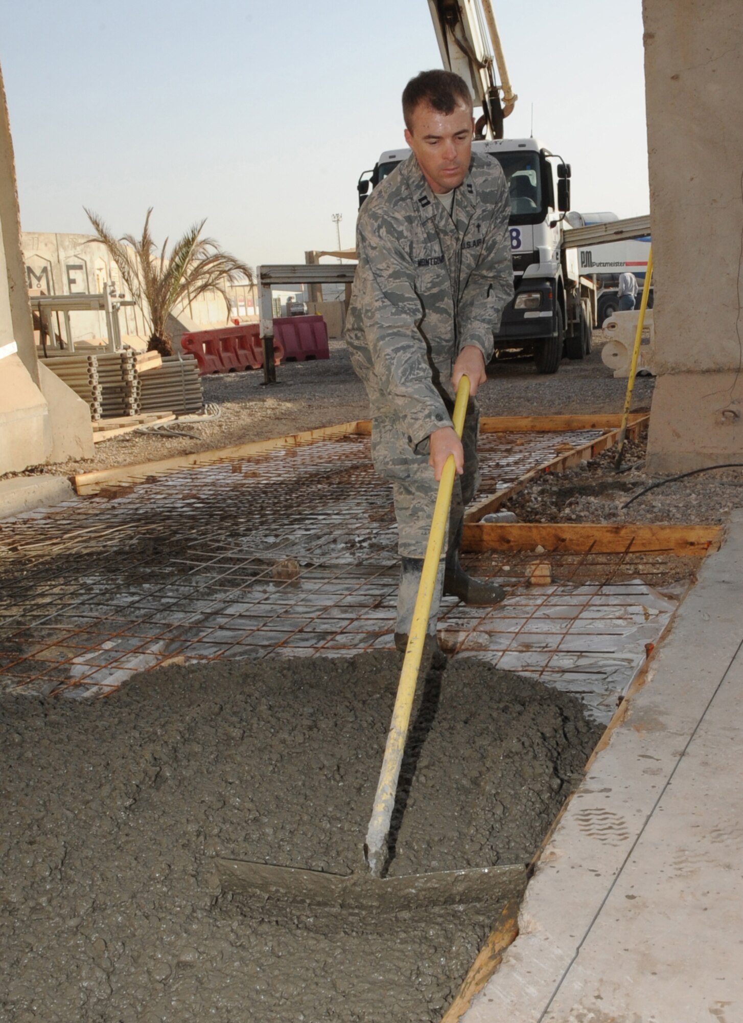SATHER AIR BASE, Iraq -- Air Force Chaplain (Capt.) Chad Montgomery, 447th Air Expeditionary Group, levels concrete for a sidewalk here Sept. 11, 2009. Chaplain Montgomery has made it his goal to get involved by helping Airmen with their daily missions and training during his deployment. Chaplain Montgomery is deployed from Lackland Air Force Base, Texas, and is a native of Newtown Square, Pa. (U.S. Air Force photo/Tech. Sgt. Johnny L. Saldivar)