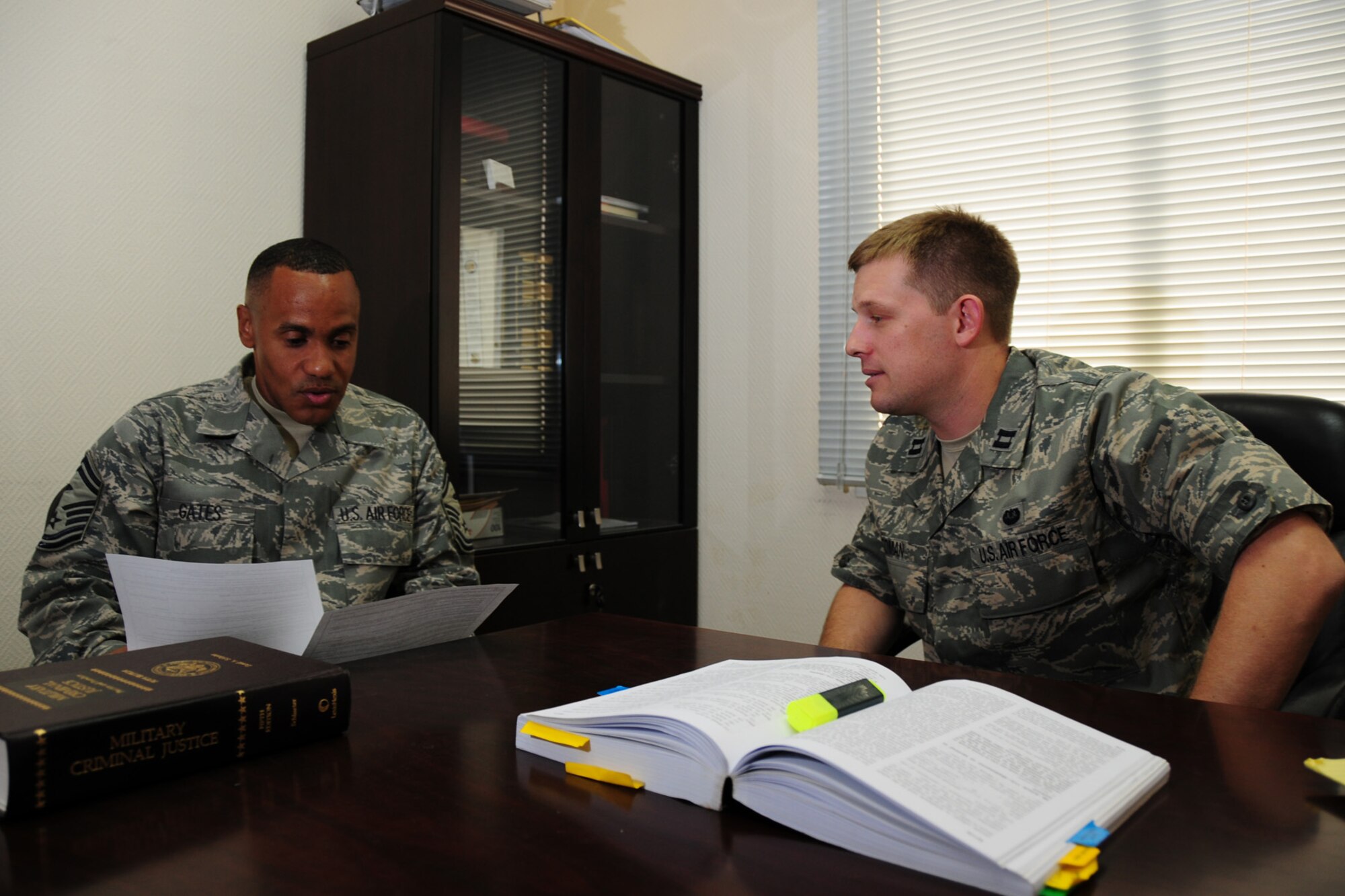 Right, Capt. John Toman, 379th Air Expeditionary Wing chief of military justice, advises Senior Master Sgt. Rodney Gates, 379th Expeditionary Maintenance Squadron first sergeant, on legal matters, here, Sept. 16. Captain Toman is deployed from Kadena Air Base, Japan. Sergeant Gates is deployed from Lackland Air Force Base, Texas. Both are deployed in support of Operations Iraqi and Enduring Freedom. (U.S. Air Force Photo/Tech. Sgt. Jason W. Edwards)