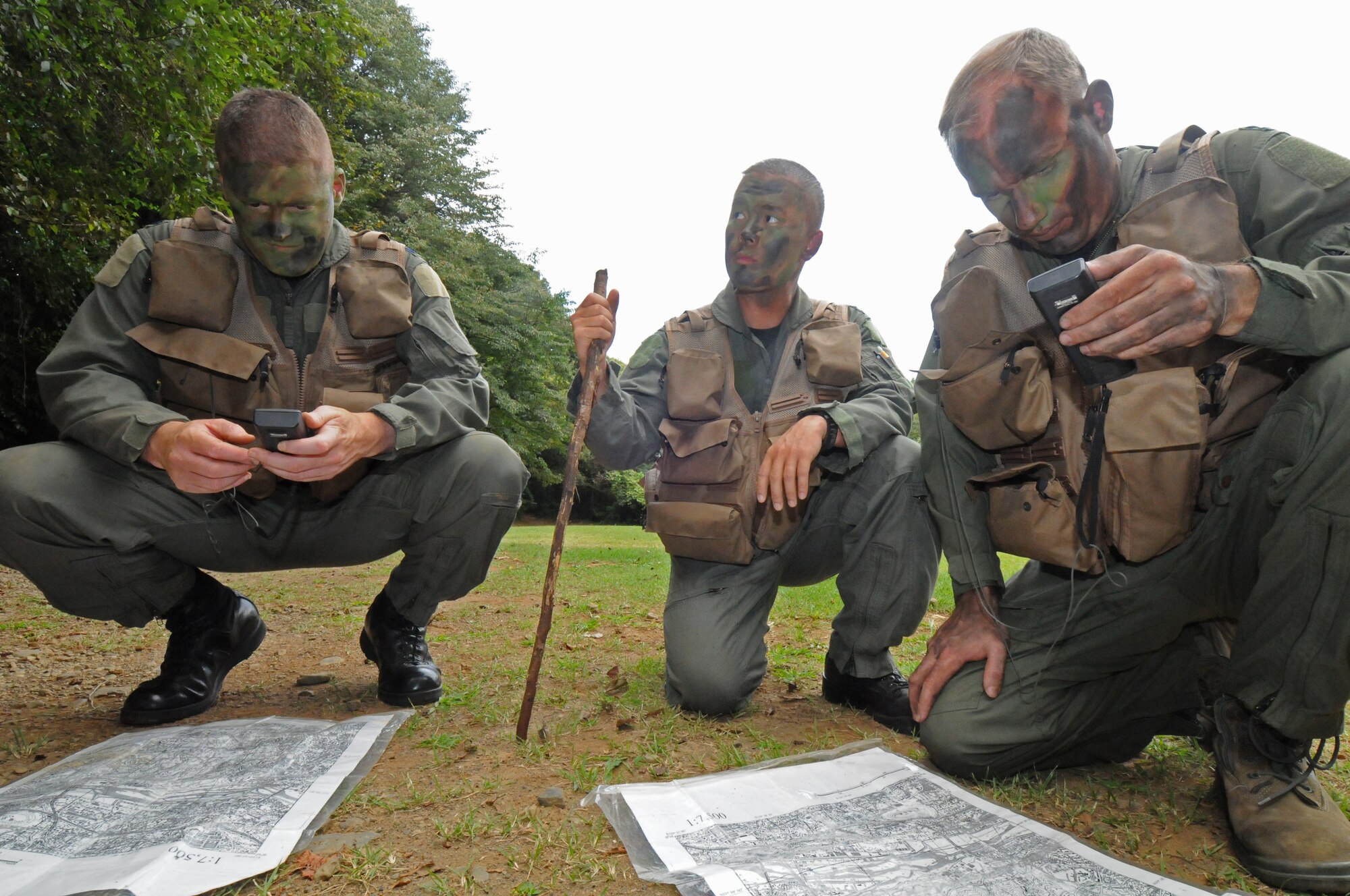 YOKOTA AIR BASE, Japan -- (Left to right) Lt. Col. Tim Rapp, 374th Airlift Wing chief of safety, Capt. Ryan Pham, 459th Airlift Squadron pilot, and Capt. Brett Cassidy, 374th Operations Group executive officer, plot out coordinates on a handheld global positioning system during combat survival refresher training recently at Tama Hills Recreation Area. (U.S. Air Force photo/Staff Sgt. Veronica Pierce)
