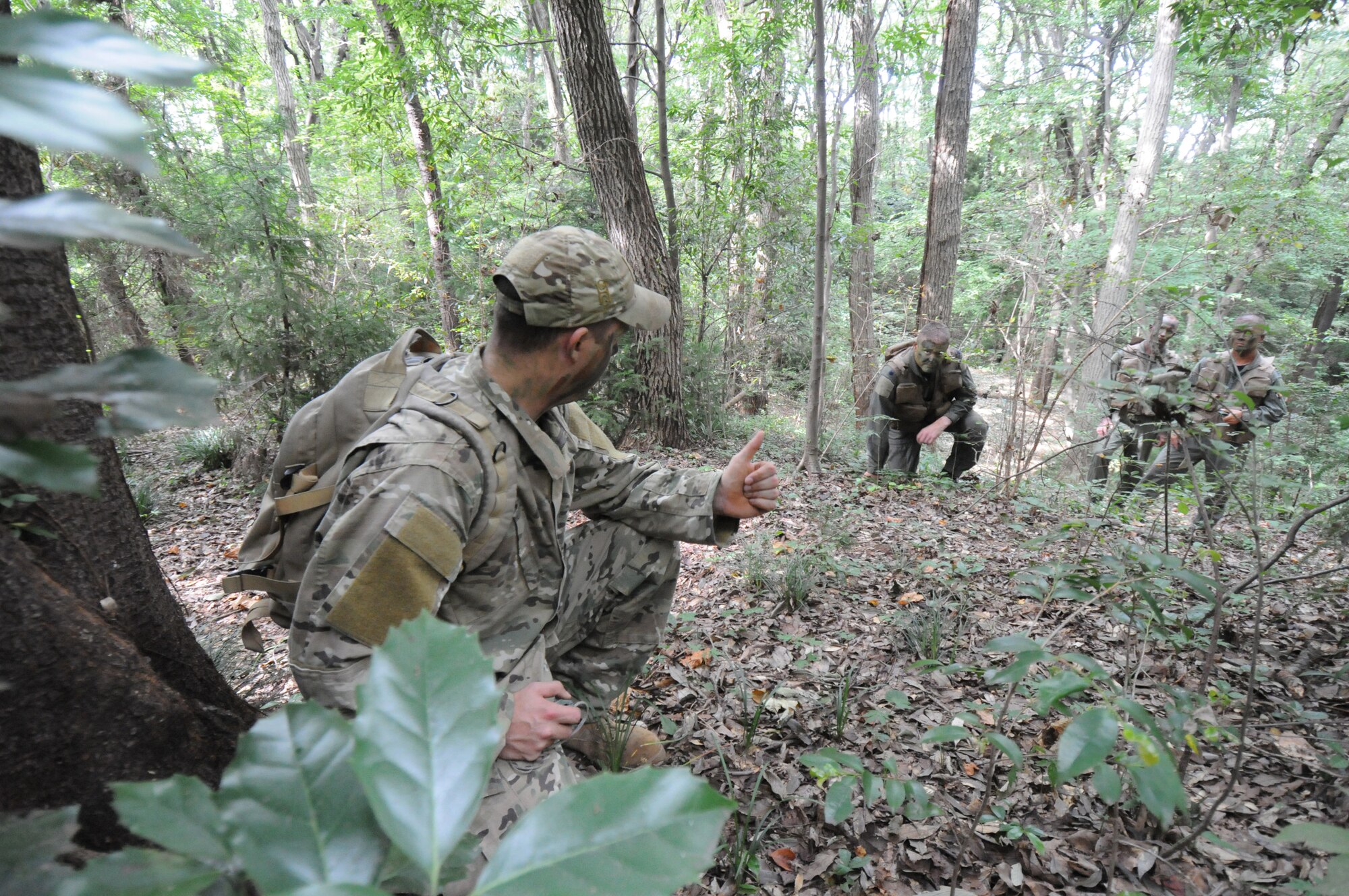 YOKOTA AIR BASE, Japan -- Staff Sgt. Benjamin Rosciglione, 374th Operations Support Squadron Survival, Evasion, Resistance and Escape specialist, (foreground) instructs aircrew members on how to tactically evade an enemy during combat survival refresher training recently at Tama Hills Recreation Area. (U.S. Air Force photo/Staff Sgt. Veronica Pierce) 
