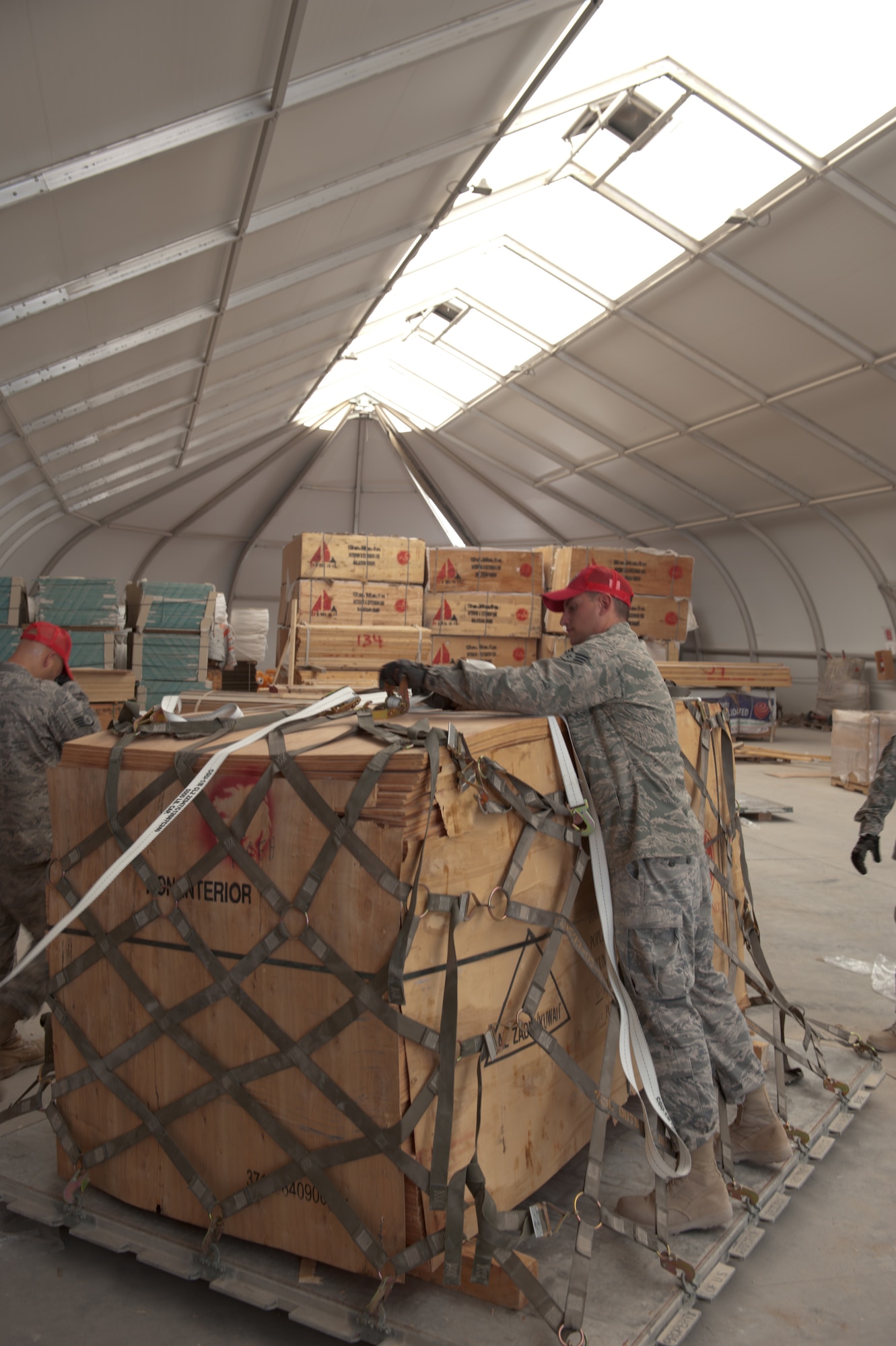 U.S. Air Force Senior Airman Ryan McGraw, 1st Expeditionary RED HORSE Group structural journeyman, secures a pallet of wood to be palletized and shipped to Bagram Airfield, Sept. 15, in Southwest Asia. Airman McGraw, along with fellow servicemembers of the logistics and pallet build-up team, support all RED HORSE operations downrange by obtaining and shipping required equipment for mission success. Airman McGraw is deployed from Dyess Air Force Base, Texas, in support of Operations Iraqi and Enduring Freedom. (U.S. Air Force Photo/Staff Sgt. Robert Barney/RELEASED)