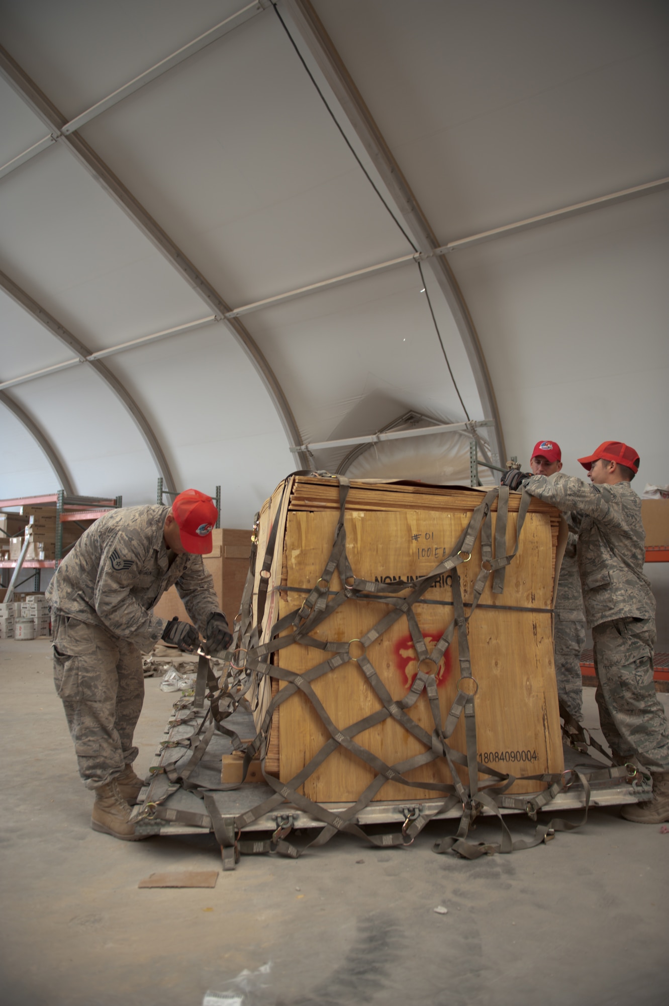 U.S. Air Force servicemembers of the 1st Expeditionary RED HORSE Group logistics and pallet build-up team secure a pallet of wood to be shipped to Bagram Airfield, Sept. 15, in Southwest Asia. Personnel assigned to the logistics and pallet build-up team support all RED HORSE operations downrange by obtaining and shipping required equipment for mission success. The team is deployed in support of Operations Iraqi and Enduring Freedom. (U.S. Air Force Photo/Staff Sgt. Robert Barney/RELEASED)