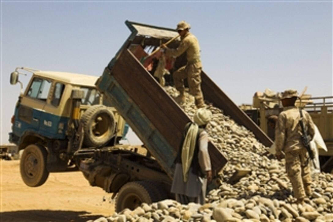 U.S. Marines with 1st Battalion, 5th Marine Regiment and Afghan contractors dump gravel at Marine Corps Forward Operating Base Geronimo, Nawa district, Helmand province, Afghanistan, on Sept. 13, 2009.  The gravel is being used in the construction of Forward Operating Base Geronimo.  The Marines are the combat element of Regimental Combat Team 3, whose mission is to conduct counterinsurgency operations in partnership with Afghan security forces in southern Afghanistan.  