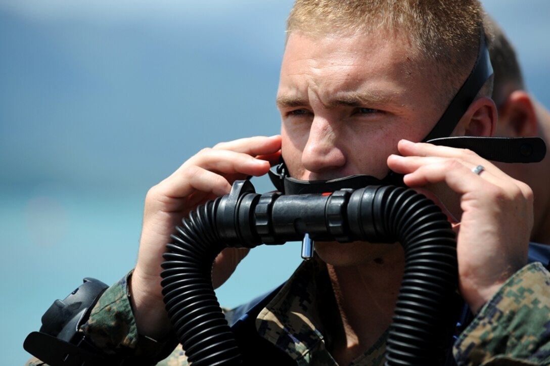 Staff Sgt. Bo Irving adjusts an underwater breathing apparatus while diving in Kaneohe Bay, Hawaii, Sept. 17. Irving and other members of Reconnaissance Platoon, Battalion Landing Team 2/4, practiced insertion methods during final training before deploying Sept. 24 with 11th Marine Expeditionary Unit. The apparatus, a Draeger LAR-V rebreather, does not produce bubbles and is used for clandestine underwater insertion. Irving is the platoon’s special equipment noncommissioned officer.