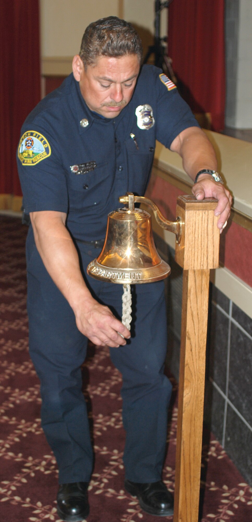 Tom Hayes, March ARB Fire Department, rings the bell a total of nine times to remember the firefighters who died on Sept. 11, 2001. (U.S. Air Force photo by Megan Just)
