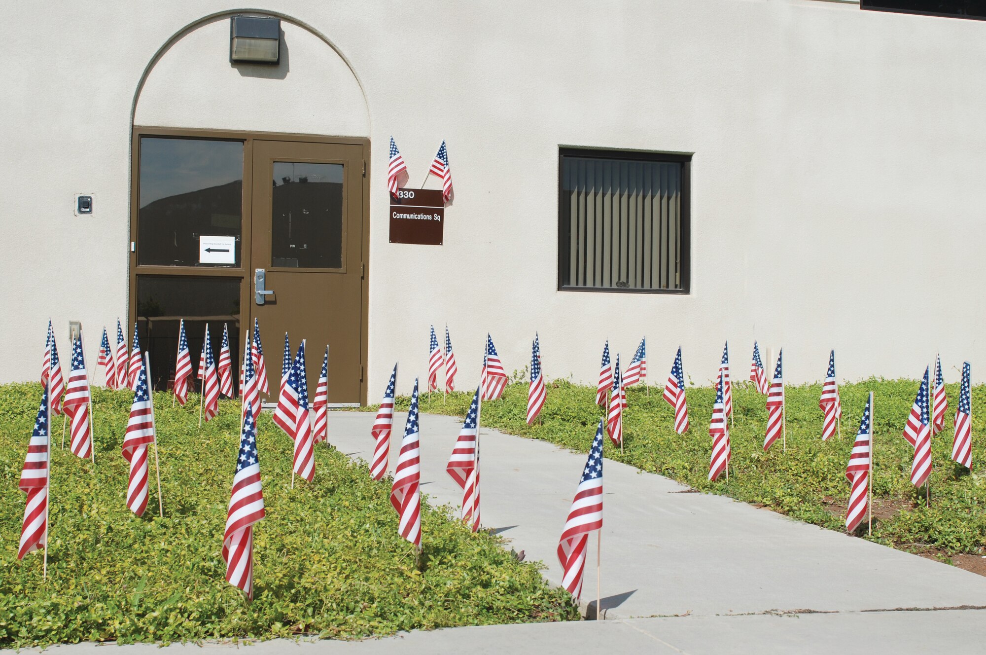 Debbie Meredith, and her co-workers at the Communications Annex, placed over 100 flags in front of building 2330 on Sept. 11. “I wanted to remind everybody that it was 9/11,” she said. The flags were their way of showing respect for the victims of the tragedies and also for military service members. (U.S. Air Force photo by Valerie Palacios)