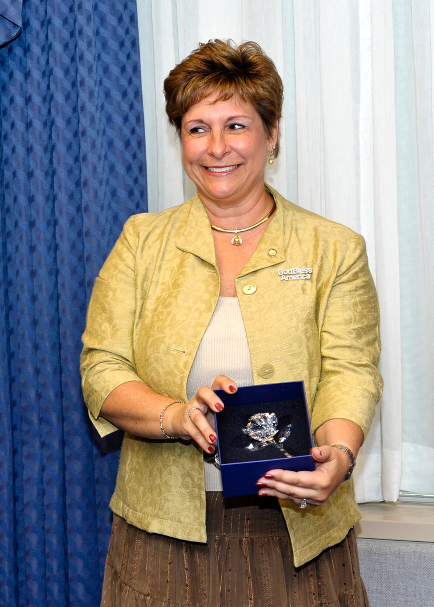 Marianne Williams, wife of Brig. Gen. Brett Williams, shows the crystal rose she received after the couple was honored with the 2009 General and Mrs. Jerome O'Malley Award during a ceremony in the Pentagon Sept. 11, 2009.  The rose was presented to Mrs. Williams by Sharon O'Malley Burg to carry on the O'Malley legacy.  (U.S. Air Force photo/Michael Pausic)