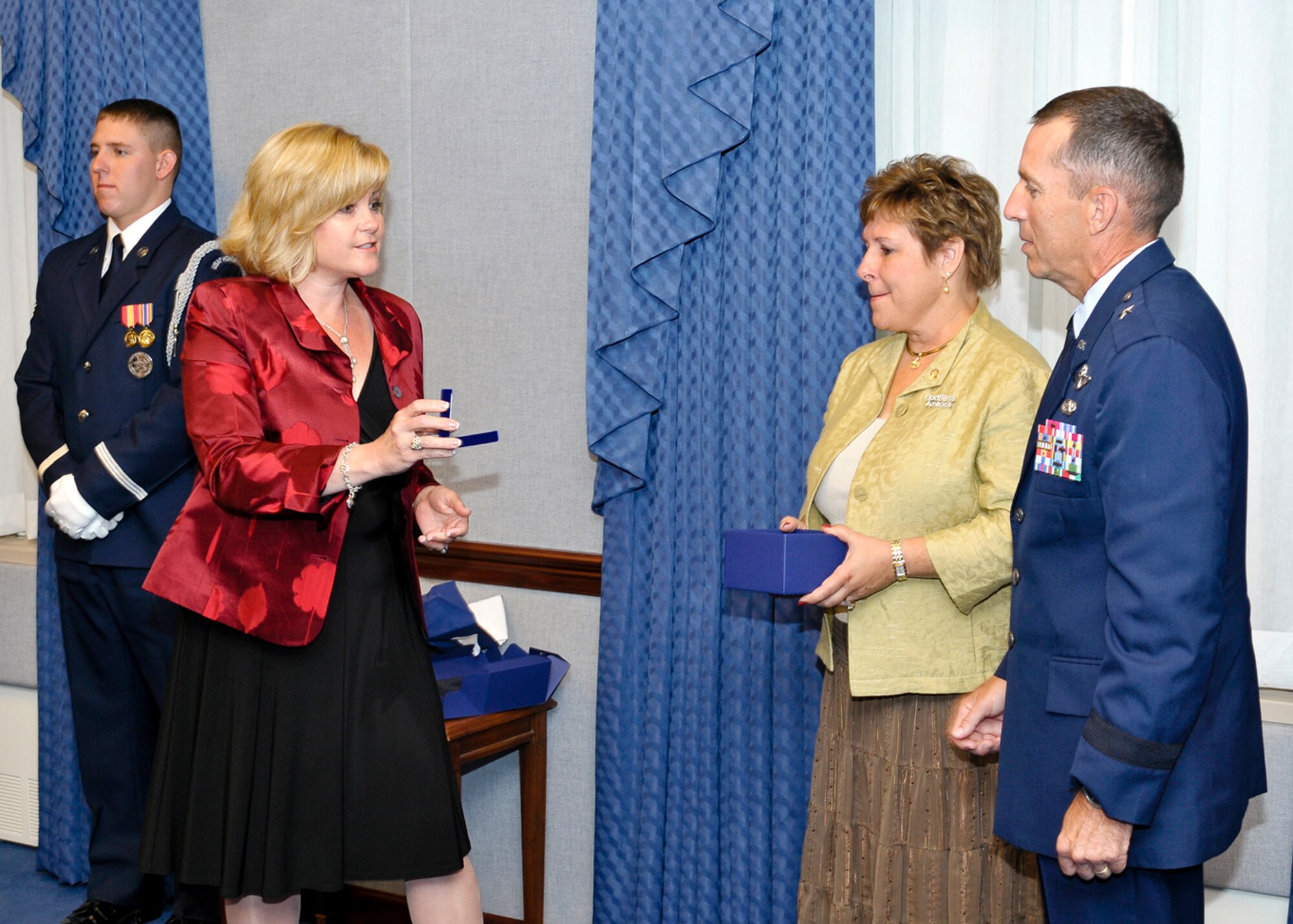 Sharon O'Malley Burg, daughter of the late Gen. Jerome and Diane O'Malley, presents Brig. Gen. Brett Williams with a set of brigadier general rank worn by General O'Malley as a special tribute to carry on the O'Malley legacy.  The presentation of the rank was part of a ceremony at the Pentagon Sept. 11, 2009, where General Williams and his wife, Marianne, were honored with the 2009 General and Mrs. Jerome O'Malley Award. The award was established after the O'Malleys, who were known for their leadership and contributions to Air Force families and communities, were killed in a plane crash in 1985.  (U.S. Air Force photo/Michael Pausic)