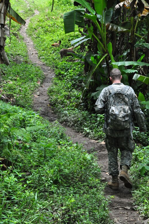 U.S. Army Sgt. Ben Washburn walks down a jungle path between the helicopter landing zone and the site of a Medical Readiness and Training Exercise in Xiomara, Costa Rica, Sept. 12, 2009. Sergeant Washburn is a broadcast journalist assigned to Armed Forces Network, Honduras. (U.S. Air Force photo/Tech. Sgt. Mike Hammond)