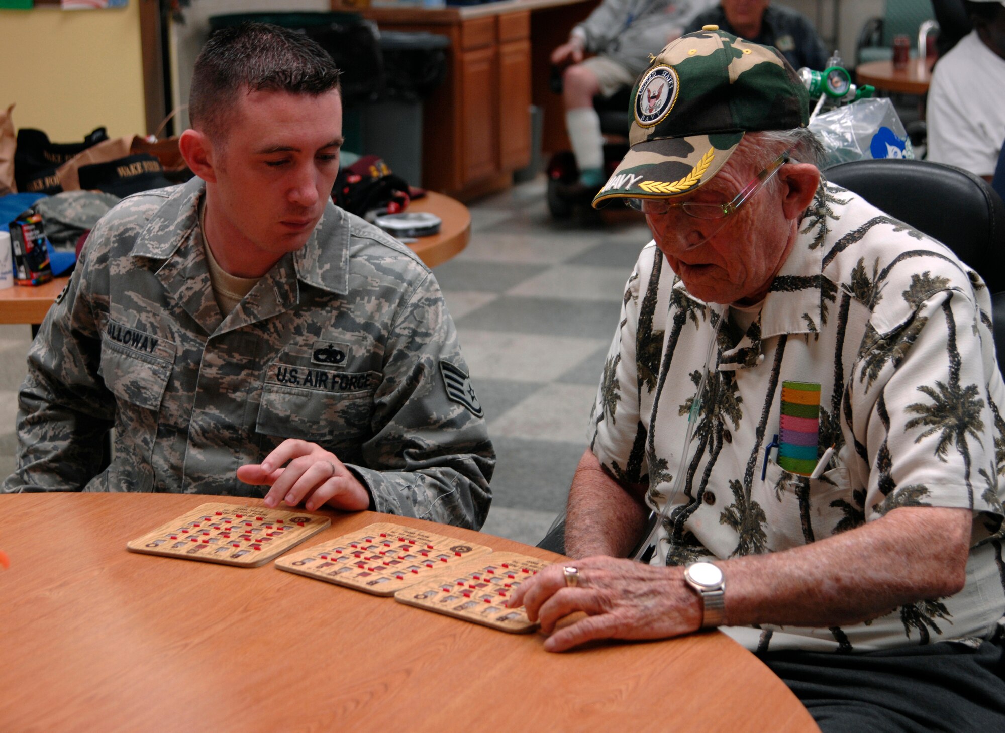 Staff Sgt. Charles Galloway, 22nd Communications Squadron, assists Darrell Knight, 1940s Navy veteran, in a bingo game, Sept. 17, 2009, at the Robert J. Dole Veteran Affairs Medical Center, Wichita, Kan. Sergeant Galloway was among 13 team McConnell members to participate in the event. VA bingo gives current military members a chance to meet with veterans who before them. (U.S. Air Force photo/Senior Airman Laura Suttles)
