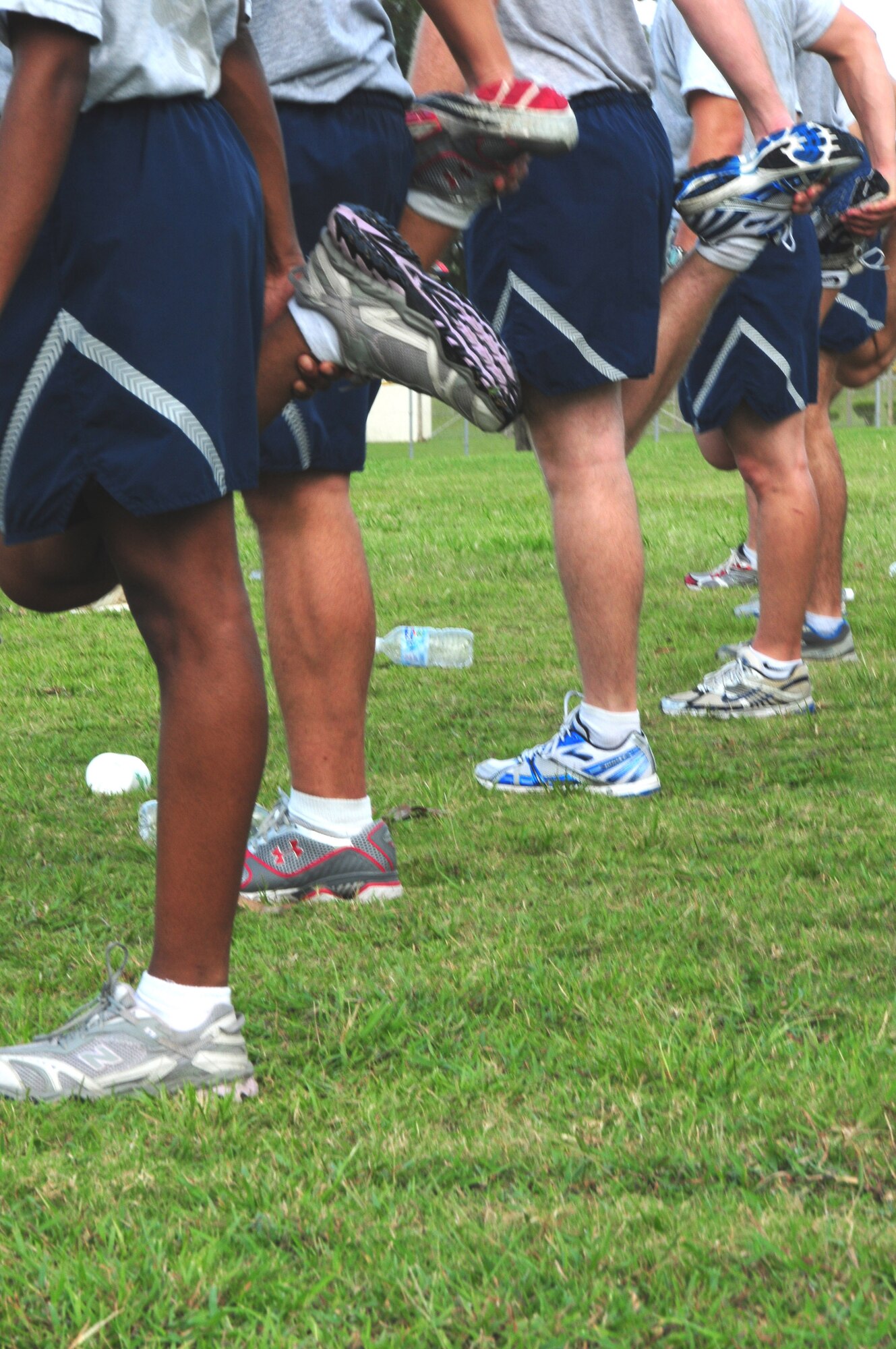 Members of the  vehicle maintenance flight of the 18th Logistics Readiness Squadron stretch their quads as part of their routine cool down after a 5K run Sept. 16, 2009, at Kadena Air Base, Japan. The original PT program was established in 2002 and was modified in 2006 to stay current with the changing Air Force fitness standards. (U.S. Air Force photo/Staff Sgt. Lakisha A. Croley)

