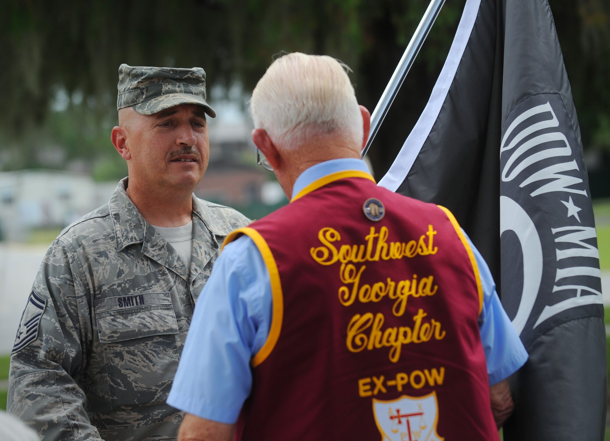 MOODY AIR FORCE BASE, Ga. -- Senior Master Sgt. David Smith, Air Force Sergeants Association, Chapter 460 vice president, presents retired 1st Lt. James Lee, a prisoner of war during World War II, with a Prisoner of War/Missing in Action flag during the POW/MIA Remembrance Day ceremony here Sept. 18. The flag was carried throughout a 23-mile run earlier in the  day by many Moody Airmen. (U.S. Air Force photo by Senior Airman Gina Chiaverotti-Paige)