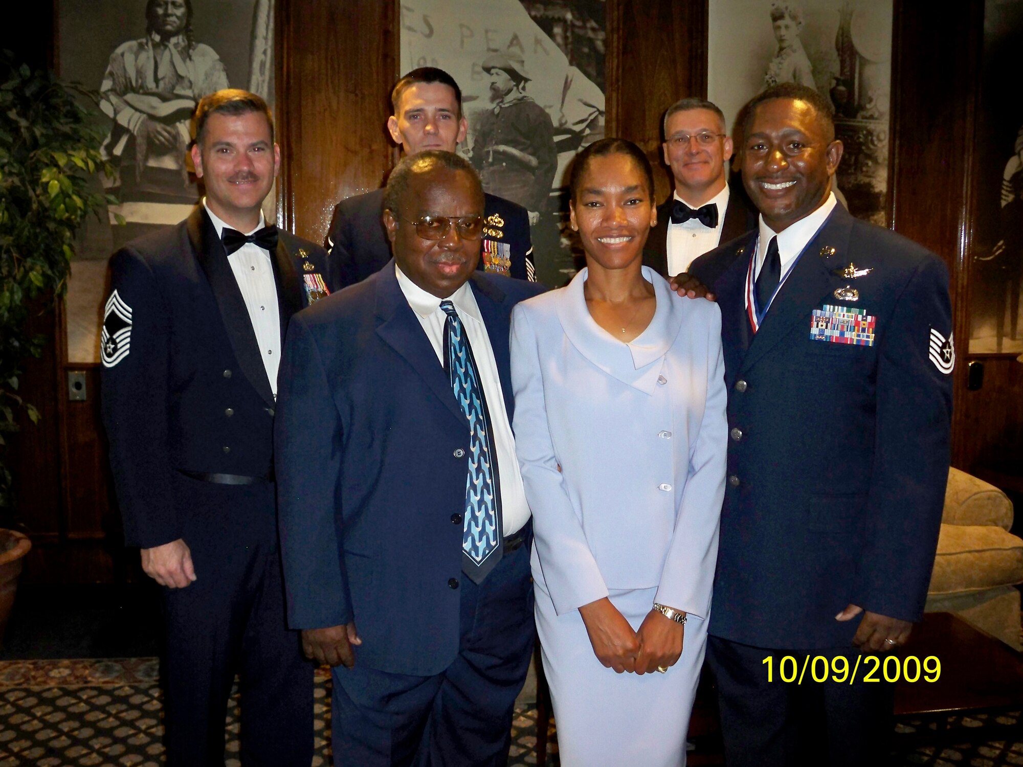 Tech. Sgt. Ramone Young, 566th Intelligence Squadron (right), poses with his family, retired Chief Master Sgt. William Young (front left) and Lori Young, and members of his squadron (back row, from left to right) Chief Master Sgt. Dale Armstrong, Master Sgt. Billy Poff and Master Sgt. Alan Weatherly. (Photo courtesy of Chief Master Sgt. Arleen Heath)
