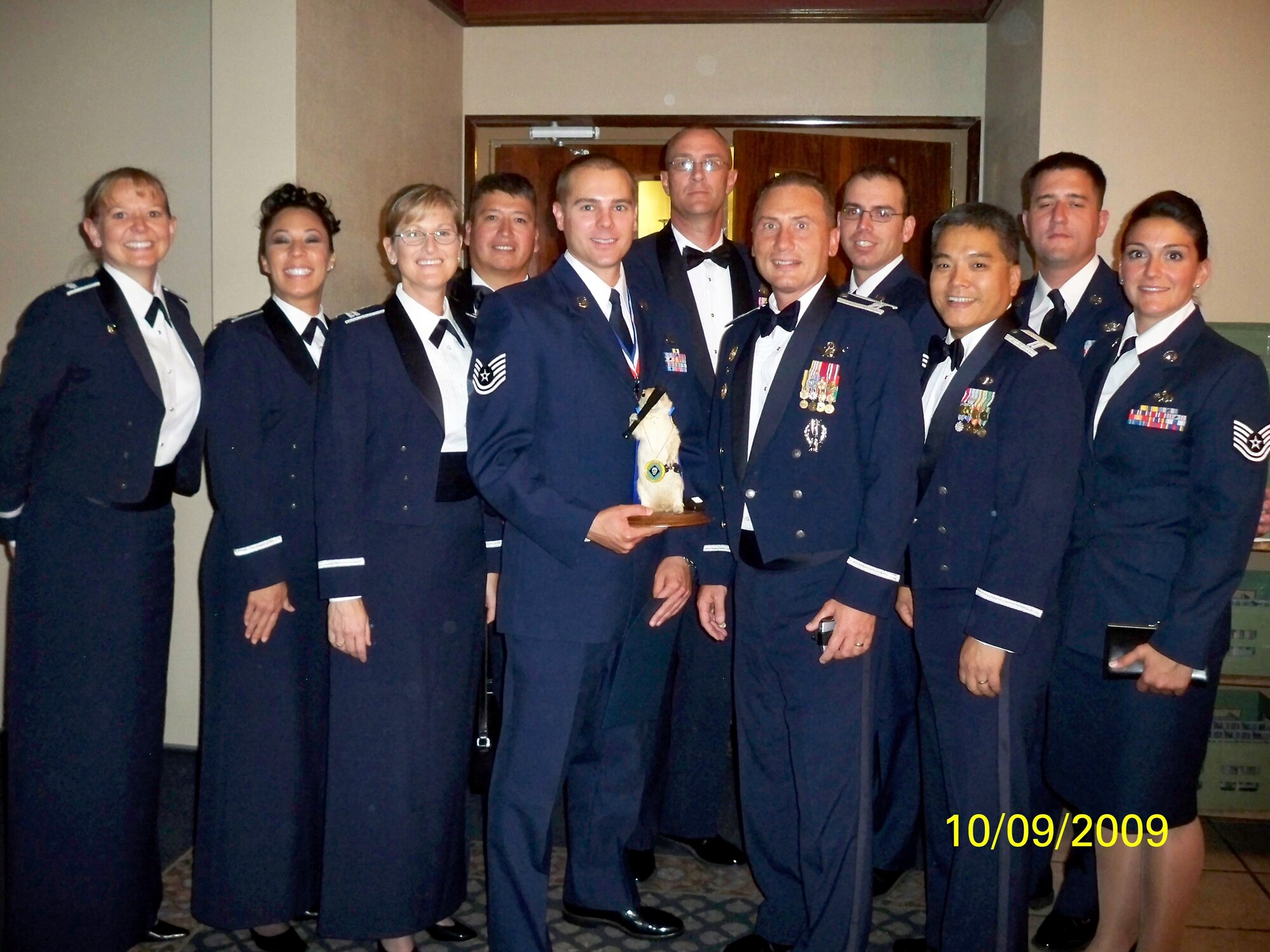 Tech. Sgt. Matthew Sadler, 2nd Space Warning Squadron (center left, holding mascot), poses with Col. Clint Crosier, 460th Space Wing commander (center right) and members of his squadron during the Peterson NCO Academy graduation Sept. 10. (Photo courtesy of Chief Master Sgt. Arleen Heath)