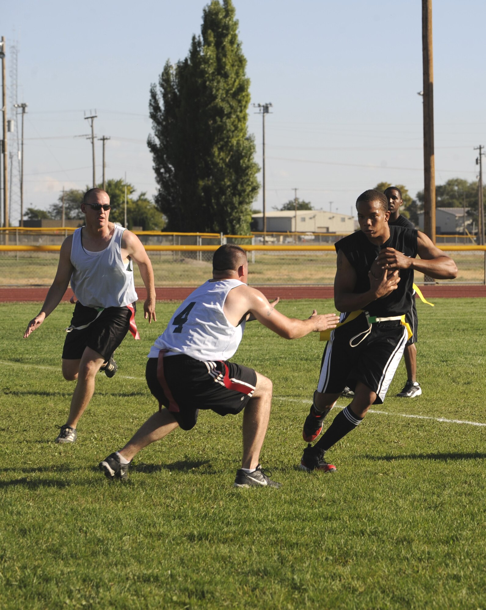 MOUNTAIN HOME AIR FORCE BASE, Idaho- - Bryant Felton, 366th Fighter Wing quarterback, carries the ball past two 366th Communication Squadron defenders Sept. 15 during an intramural flag football game. FW opened the season with an 8-0 win over CS. (U.S. Air Force photo by Airman 1st Class Renishia Richardson)