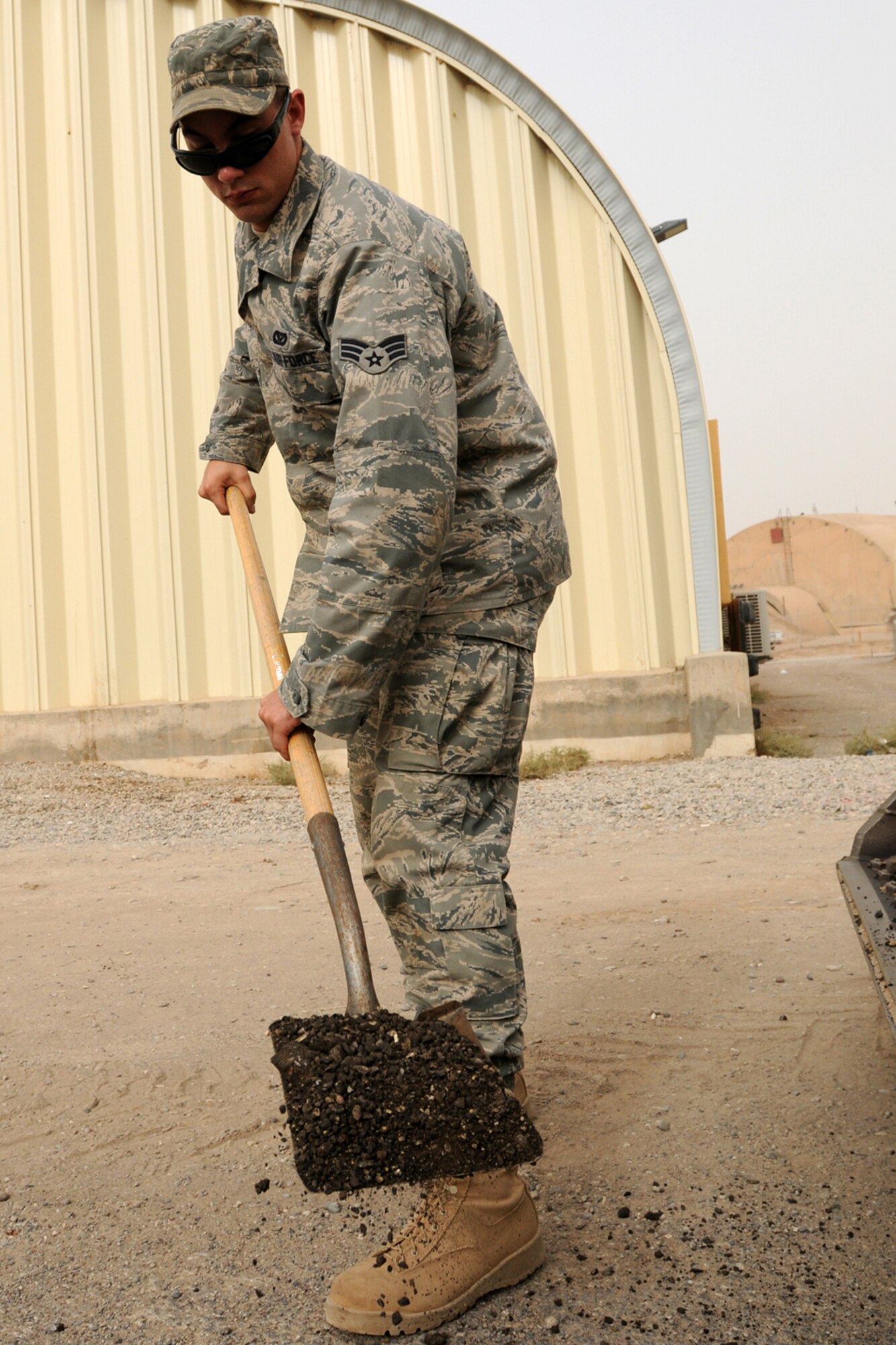 KIRKUK AB, Iraq - Senior Airman Benjamin Jenkins, 506th Expeditionary Civil Engineer Squadron, heavy equipment operator, fills a pot hole here, Sept. 17. Airman Jenkins, a Tillamook, Ore., native, is a Reservist deployed here from the 446th Civil Engineer Squadron, McChord Air Force Base, Wash. More than 40 Reserve Airmen from the 446th CES at McChord deployed to Iraq at the end of August. (U.S. Air Force photo/Staff Sgt. Joshua Breckon)
